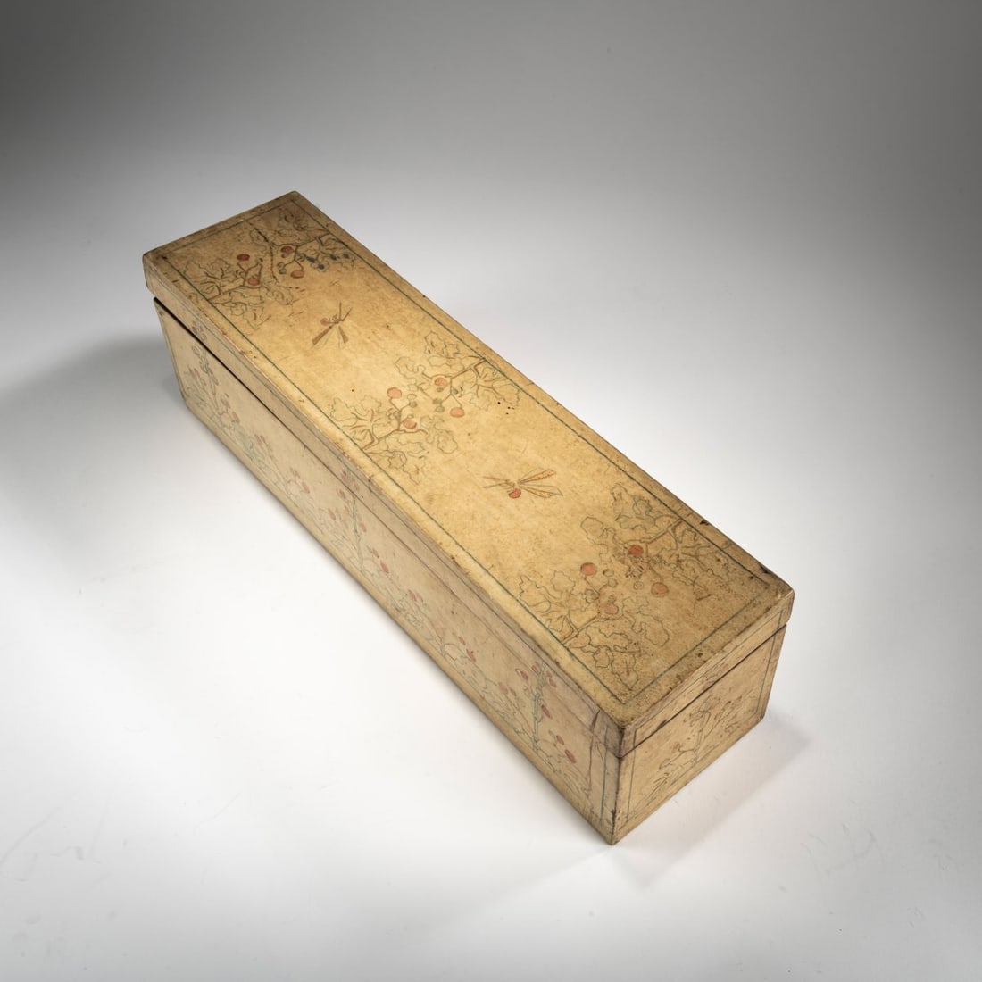 Carlo Bugatti, Jewelry box, 1902-04: H. 12.8 cm, 44.7 x 12 cm. Wood covered with parchment, painted in blue and pink with gold. Two dragonflies on the lid; plant motifs on the sides. Pink textile interior. Bottom signed: Bugatti (red, ha