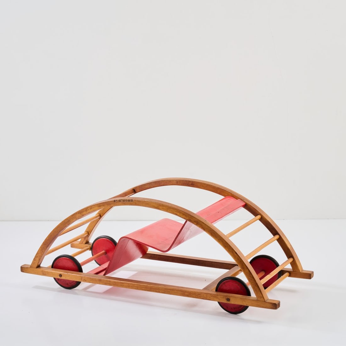 Hans Brockhage, Rocking car, 1951 (design): <p>H. 37.5 x 100 x 38.5 cm. <br />Siegfried Lenz, Berggiessh&uuml;bel / Pirna. <br />Beechwood and plywood, partially painted red, black rubber.</p>