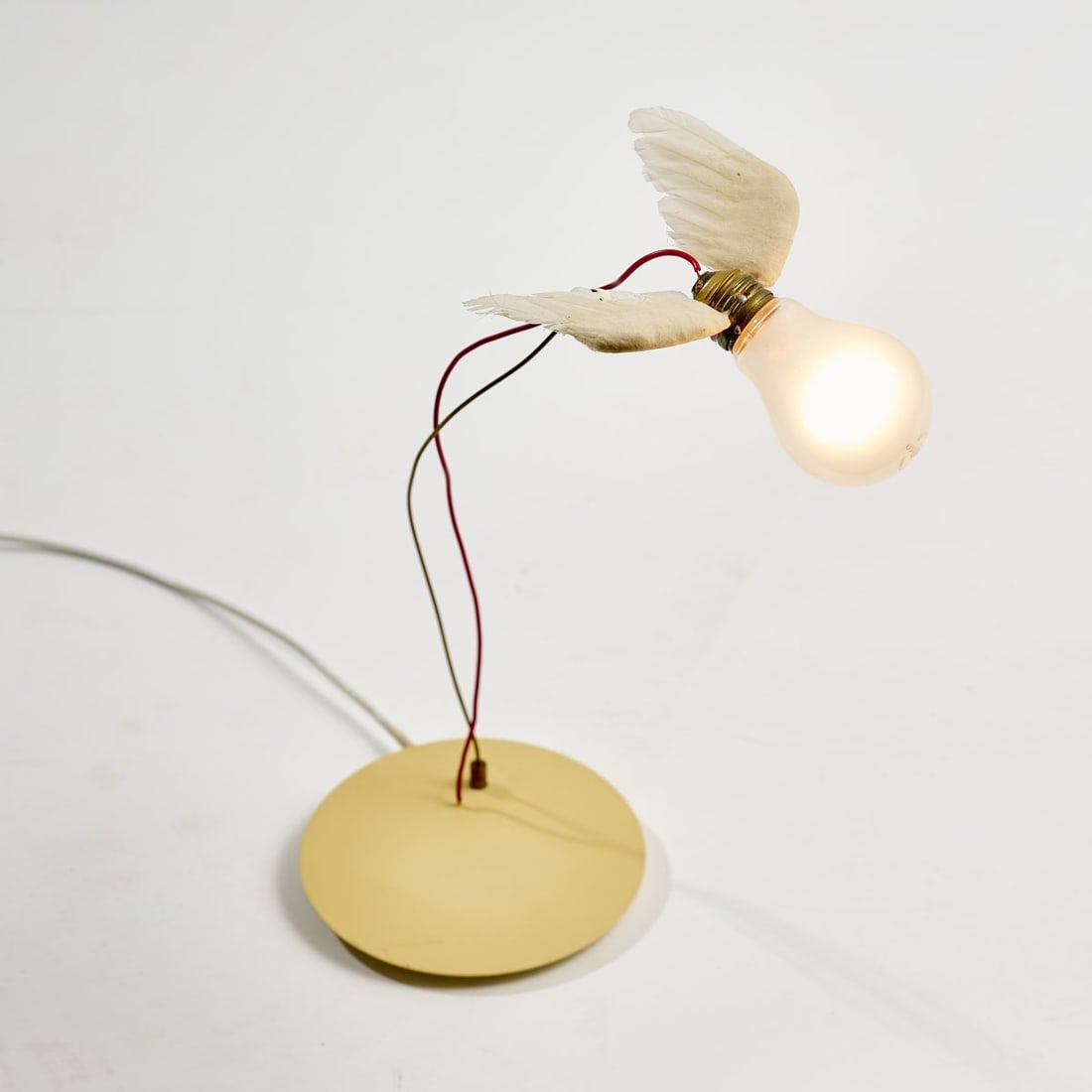 Ingo Maurer, Table light 'Lucellino', 1992: <p>H. 37 cm. <br />Design M Ingo Maurer, Munich. <br />Cast metal, cream-colored plastic, wires, goose feathers, light bulb. <br />Marked: Manufacturer's imprint and sticker, e