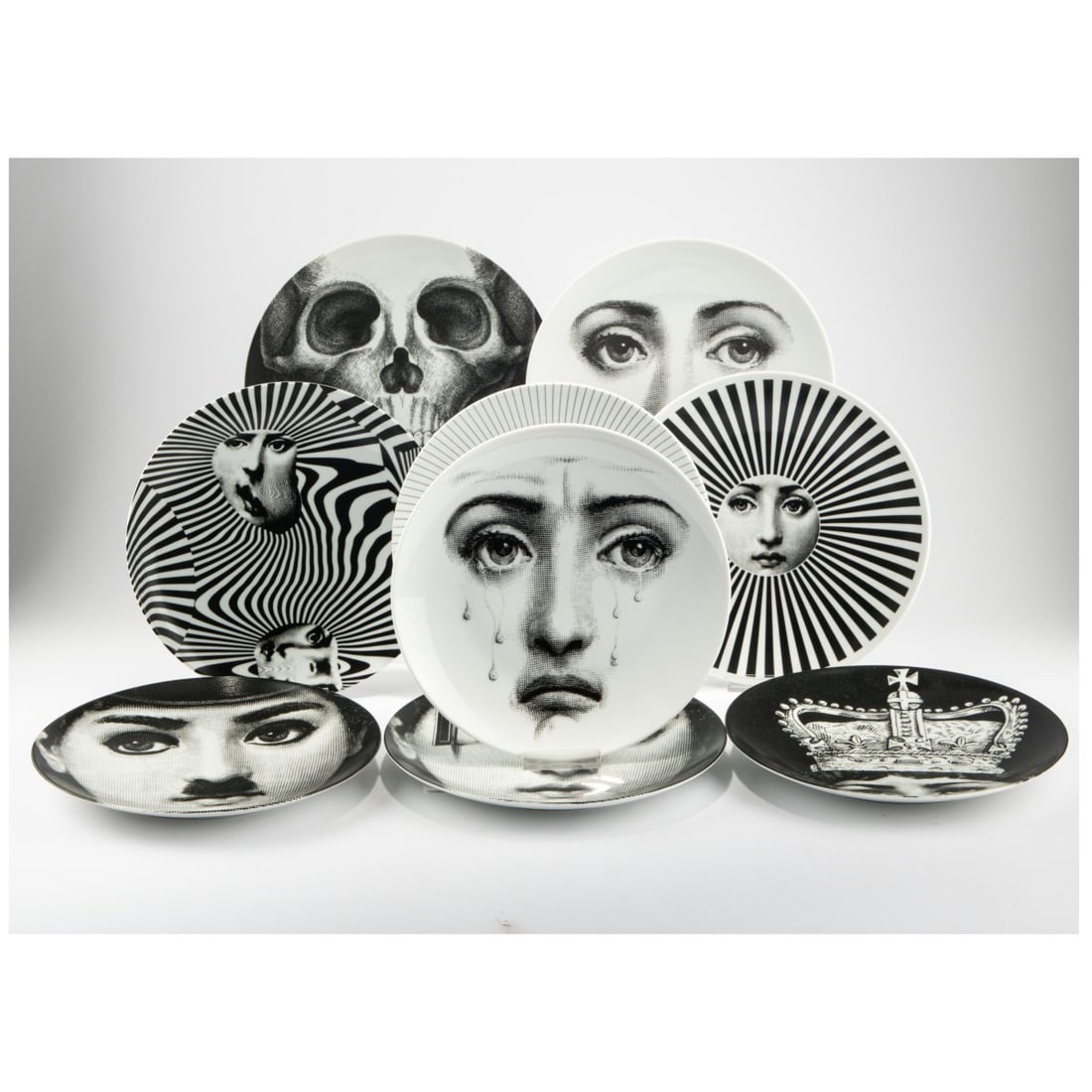 Piero Fornasetti, Nine plates from the series 'Tema e Variazione', 1960s to 2000s: <p>&Oslash; 26 cm. <br />Fornasetti, Milan. <br />Porcelain, white, glazed, with black and white lithographic decoration. <br />Marked: brush and maker's mark, 'Tema e Vari