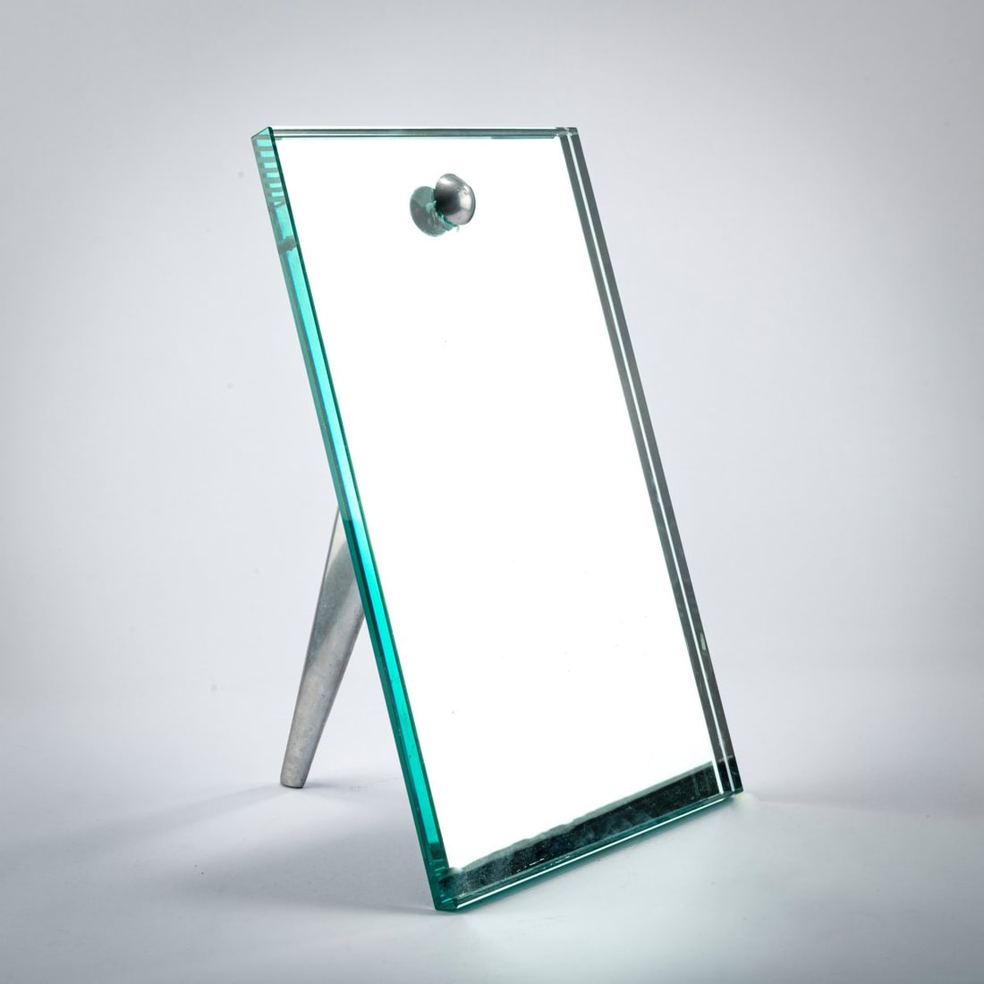 Philippe Starck , Table mirror 'Miss Donna', 1987 (design): <p>H. 41 x 24 x 24 cm. <br />OWO, Montfort-l'Amaury. <br />Polished aluminum, clear glass. <br />Marked: Manufacturer's mark with facsimile signature.</p><hr><p&