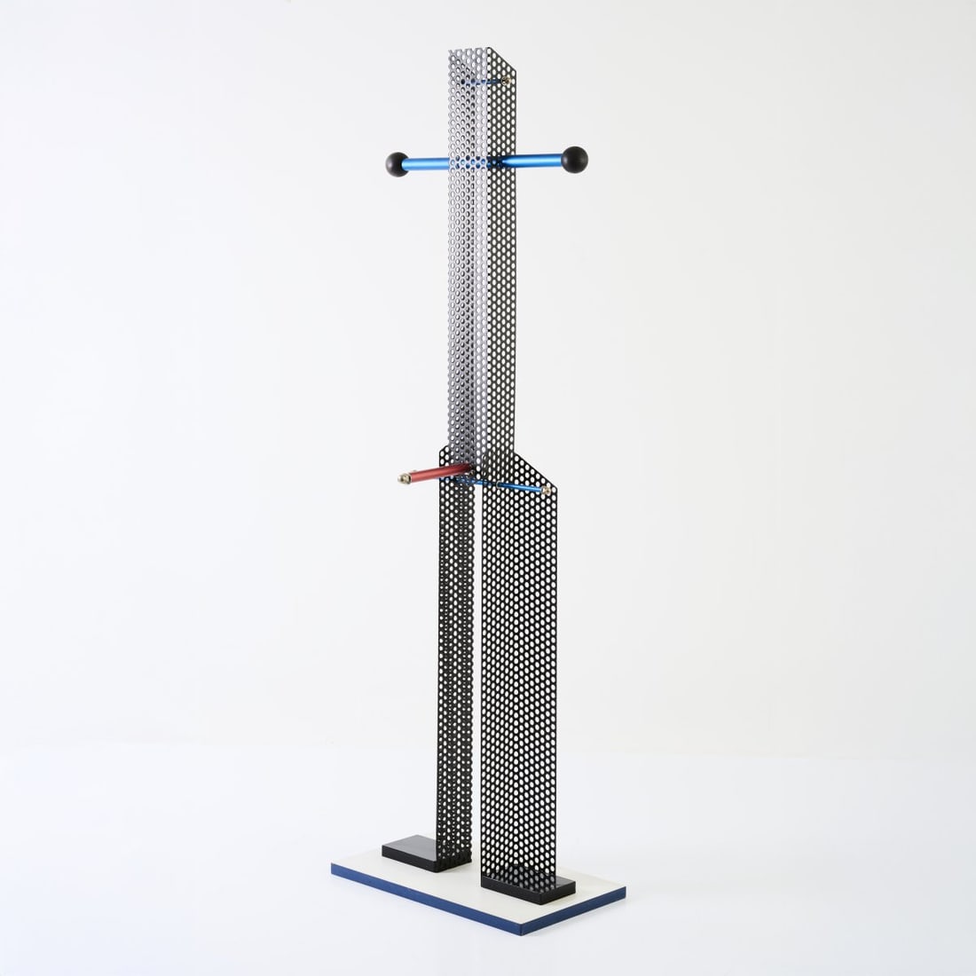 Hermann Waldenburg, Unique valet stand 'Charles', 1989: <p>H. 160.5 x 50 x 30 cm. <br />Chipboard, white laminate, sides blue, wood, painted black, black perforated metal plate, tubular metal, anodized red and blue. Rubber. <br />Marked: