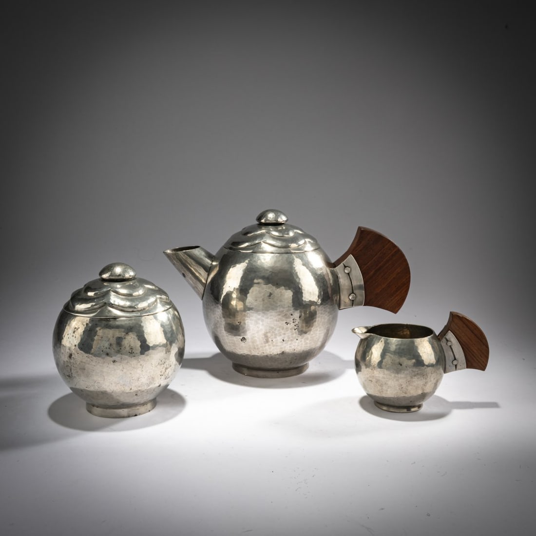 Pierre Du Mont, Paris, Three-piece tea service, c. 1928: <p>Coffee pot, creamer, and sugar bowl. H. 8-15.5 cm. Pewter, wood. Marked: Du Mont (stamped). </p>