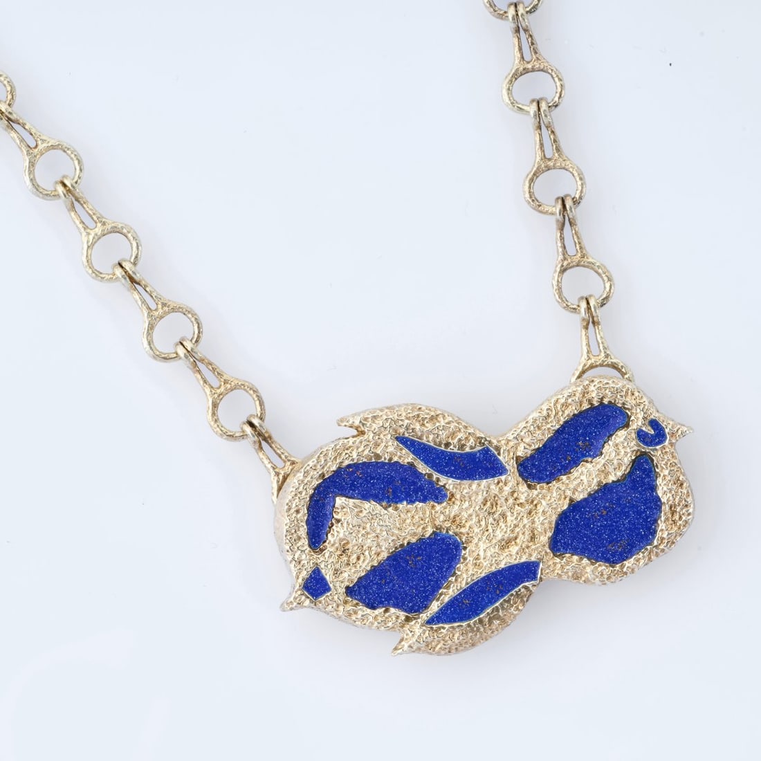 Georges Braque (after), 'Antiborée' pendant with 'Mesopotamia' chain, circa 1963 (design): <p>Sterling silver, gold-plated, blue enamel. <br />38.66 grams. Pendant 33 x 57 mm; chain length 390 mm. <br />Made by Cas Bernard, 1990s. <br />Stamped: BC, 925, Bijoux de G.