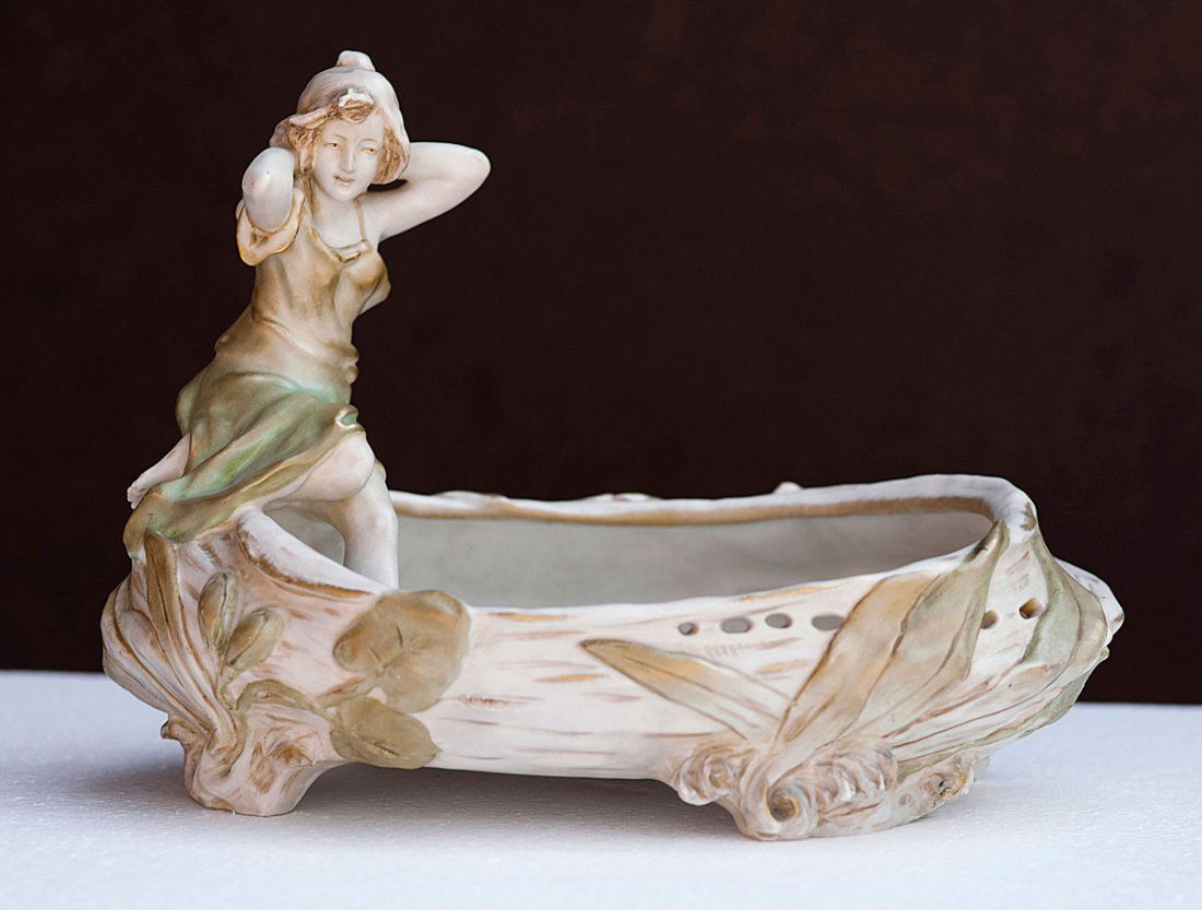 Figurative bowl, c1900: Ernst Wahliss, Vienna/Turn-Teplitz. Figurative bowl, c1900. H. 22.5 cm; 30.5 x 20.6 cm. Earthenware, reliefed, ivory white, brown and green glaze with gold. Marked: ROYAL VIENNA WAHLISS (seal), 1611,