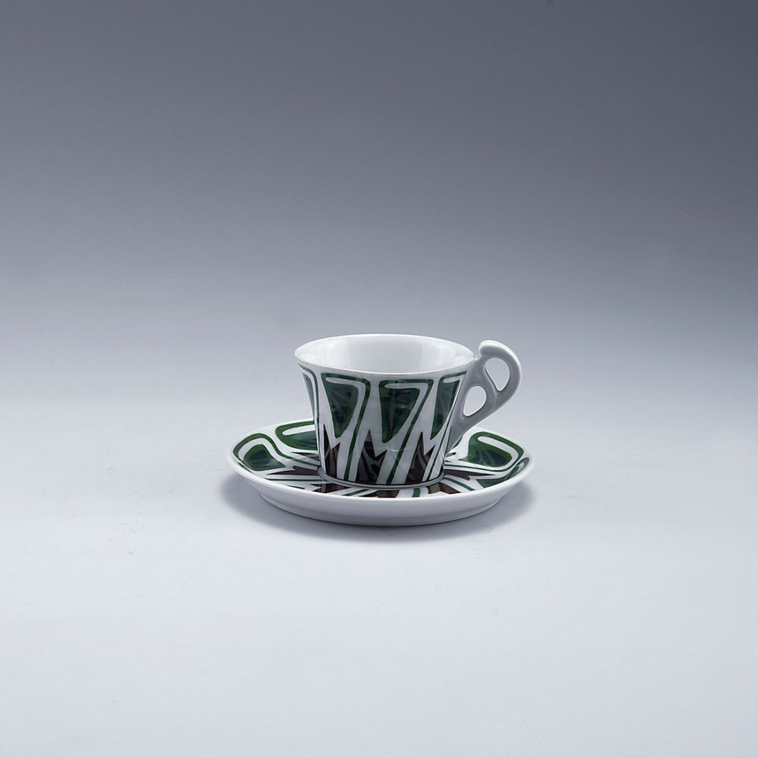 Mocha cup and saucer, 1905-09: Ferdinand Selle, Burgau. Mocha cup and saucer, 1905-09. H. 4.7 cm. Porcelain, white, glazed, overglaze, blue, brown and green. Stylised leaves. Marked: Maker's mark.
