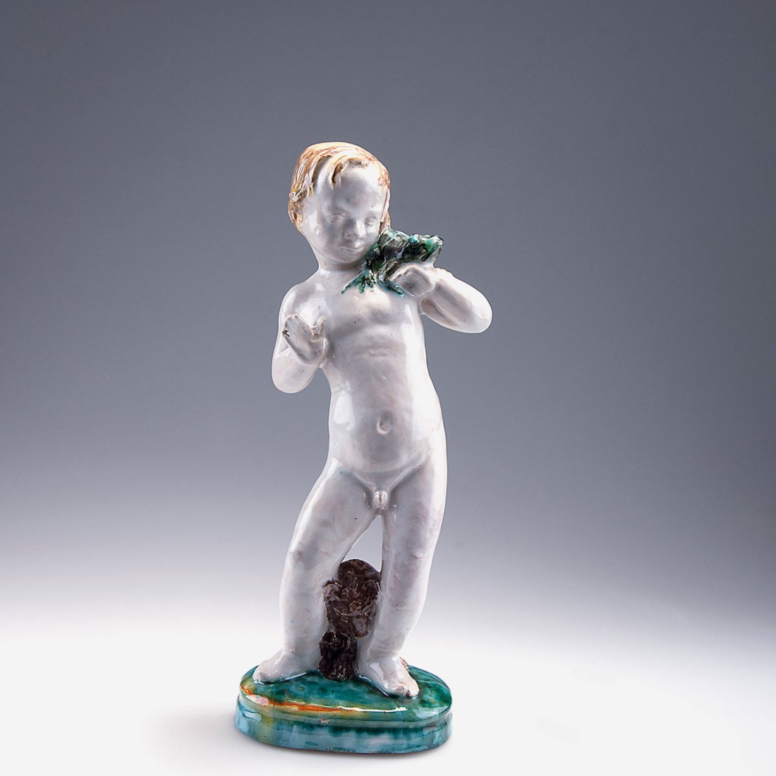 Putto with frog and bear, c1922: Georg Kemper, Munich. Putto with frog and bear, c1922. H. 33.3 cm. Earthenware, glazed white, yellow, brown and green. Marked: KEMPER MueNCHEN.