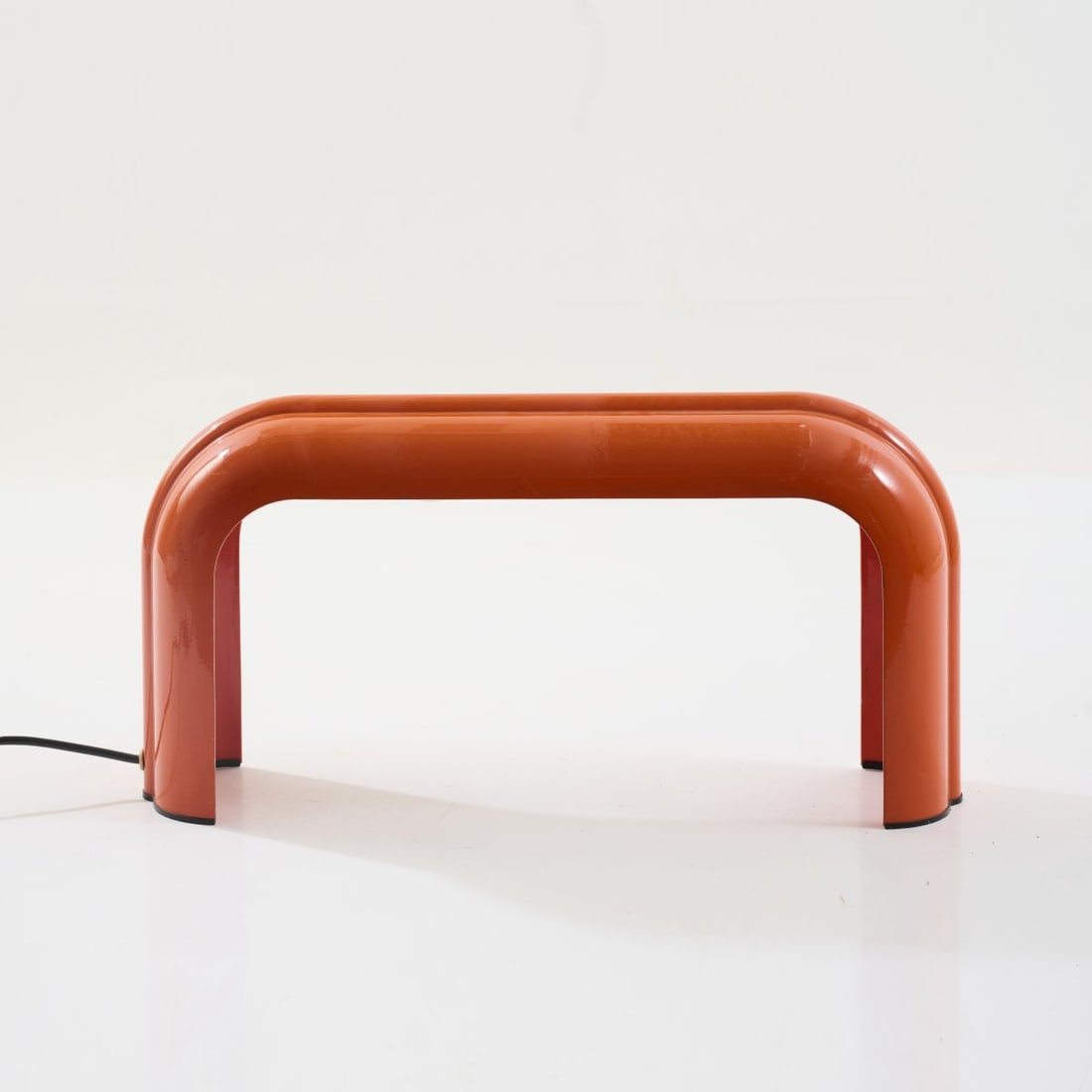 Luciano Annichini, Table light 'Eco', c. 1972 (design): <p>H. 25.5 x 51.5 x 12.5 cm. <br />Artemide, Milan. <br />Cast metal, varnished orange, black plastic. <br />Marked: Manufacturer's stamp.</p>