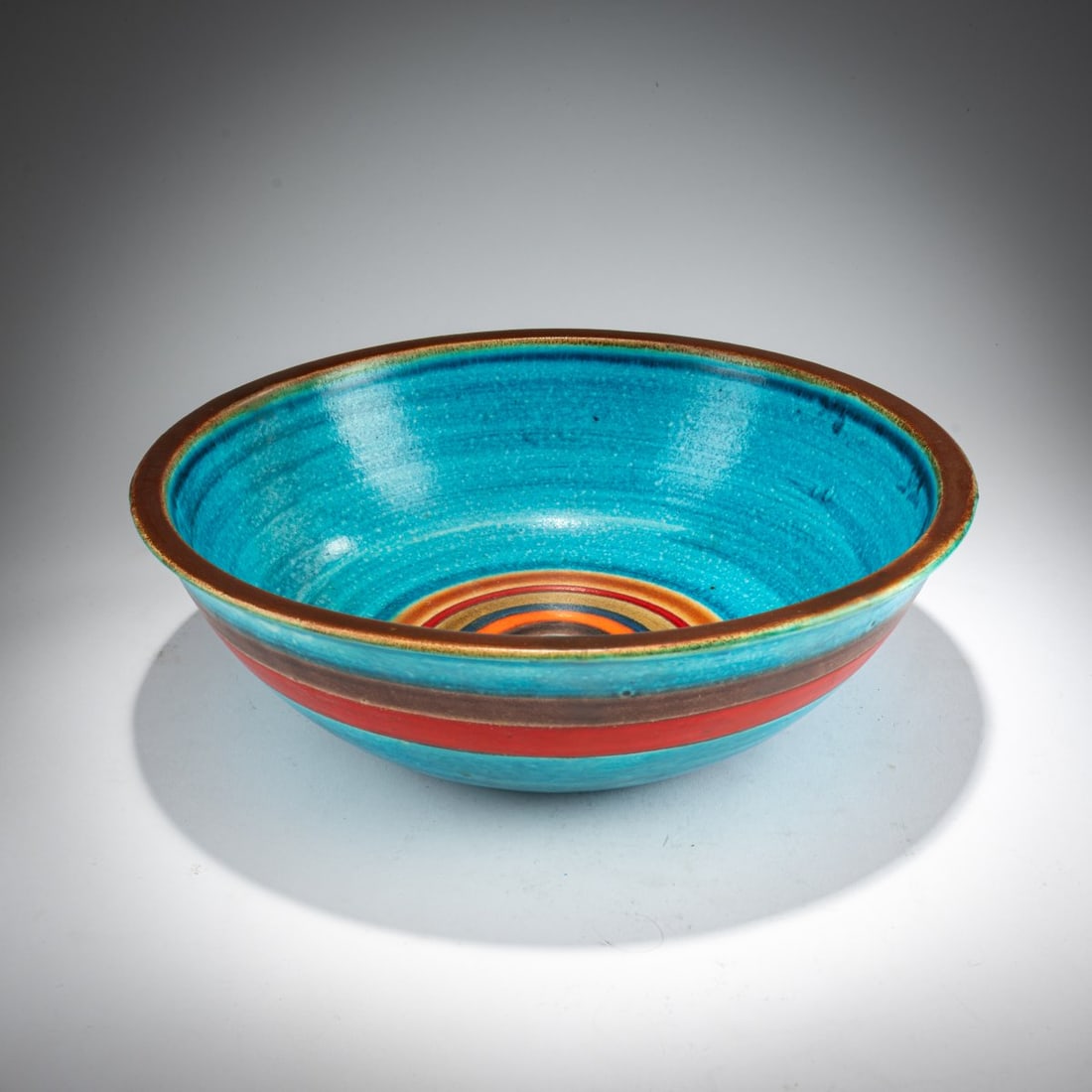 Bruno Gambone, Large bowl, 1960s: <p>H. 10 cm, &Oslash; 32 cm. <br />Earthenware, glazed in brown, light blue, red, dark blue, and orange. <br />Marked: GAMBONE ITALY (handwritten), remnant of a paper label. <