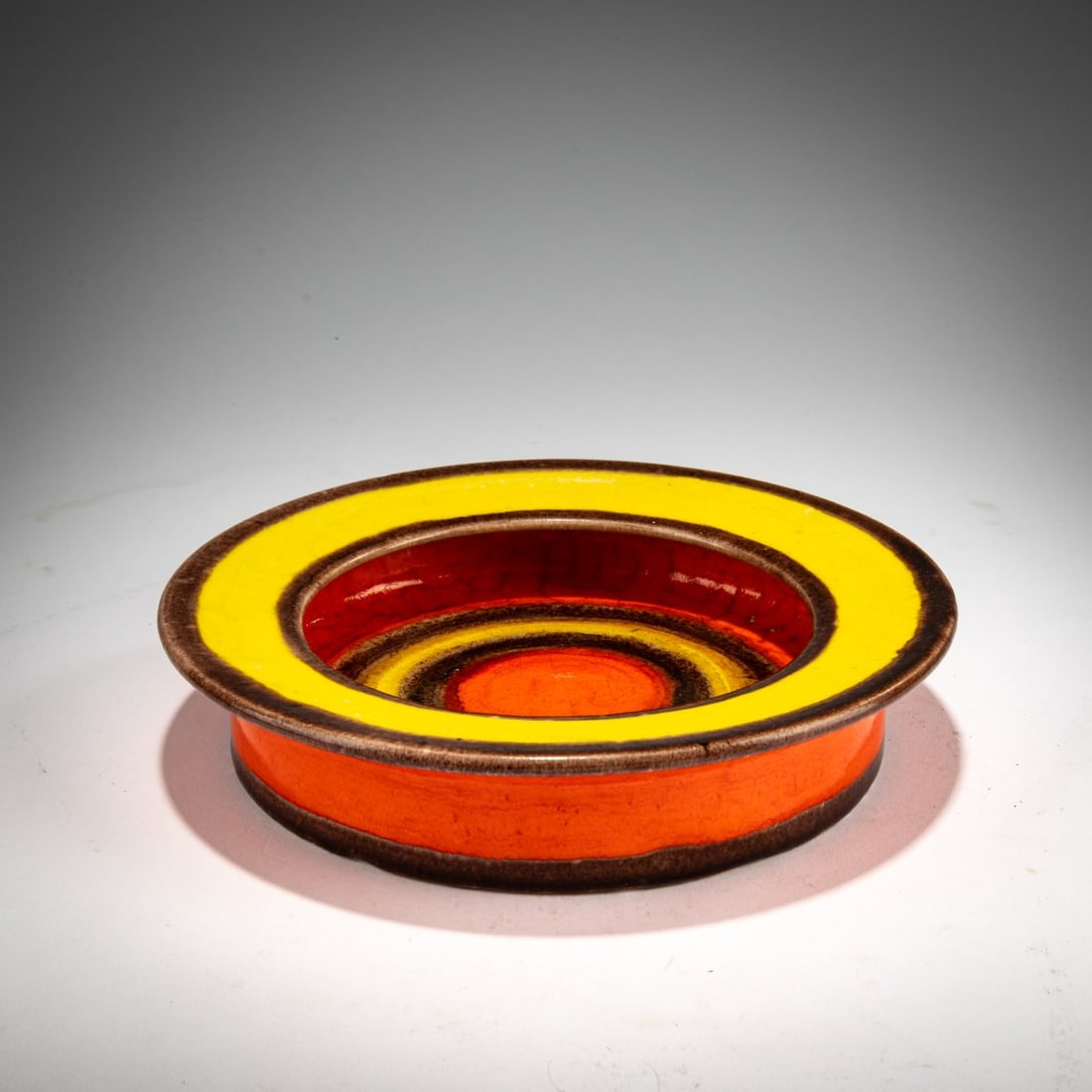 Bruno Gambone, Bowl, 1960s: <p>H 4.3 cm, &Oslash; 20.5 cm. <br />Earthenware, glazed in brown, yellow and orange. <br />Marked: GAMBONE ITALY (handwritten).</p>