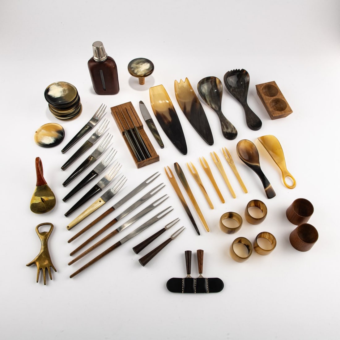 Carl Auböck, Collection of 65 objects, c. 1957: <p>Clothes brush, dustpan and broom, wine bottle holder, schnapps bottle, bottle opener, hand candle holder, pepper and salt bowl, 2 egg cups, 4 spread knives in holder, 4 fondue forks, 2 carvin