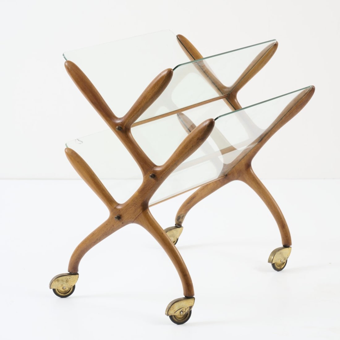 Italy, Magazine rack on casters, 1960s: <p>H. 59,5 x 53 x 42,5 cm.<br />Walnut, glass, brass, rubber.</p><hr><p>Literature:</p><p>From the Otto Bantele Collection.</p>