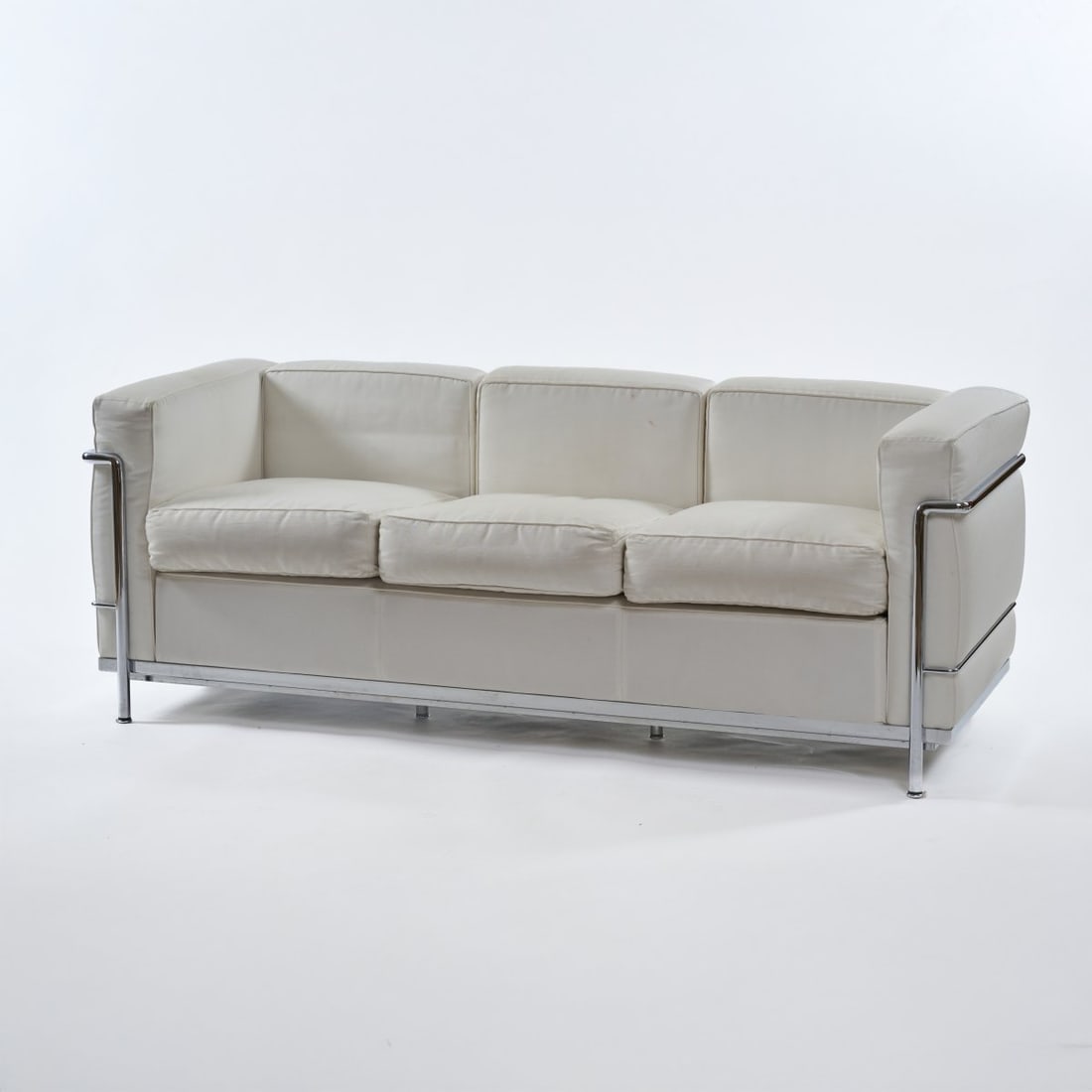 Le Corbusier Charles-Édouard Jeanneret-Gris; Pierre Jeanneret; Charlotte Perriand,: <p>H. 66.5 x 69 x 180 cm. <br />Cassina, Milan, 1990s. <br />Chrome-plated tubular steel frame, white textile upholstery. <br />Marked: Manufacturer's stamp, Cassina LC 2 No