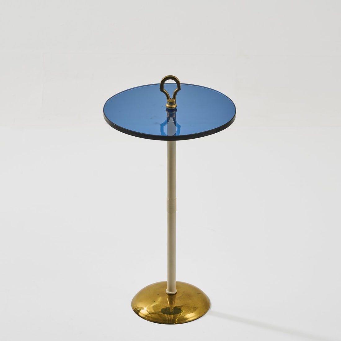 Italy, Occasional table, c. 1950: <p>H. 57.5 cm. <br />Brass sheet, brass tube, partly lacquered white, blue glass. </p>