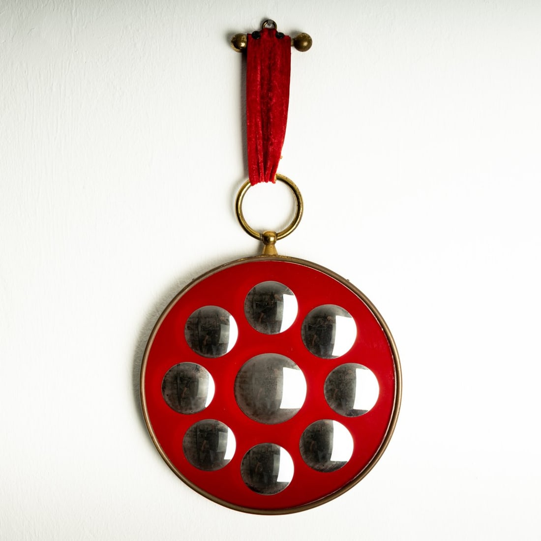 Piero Fornasetti , Wall mirror, 1950s (design): <p>H. 56.5 cm (with suspension), &Oslash;30 cm, mirror glass &Oslash; 6-8 cm each. <br />Fornasetti, Milan, 1950s-60s. <br />Plywood, brass sheet, brass balls, mirror glass,