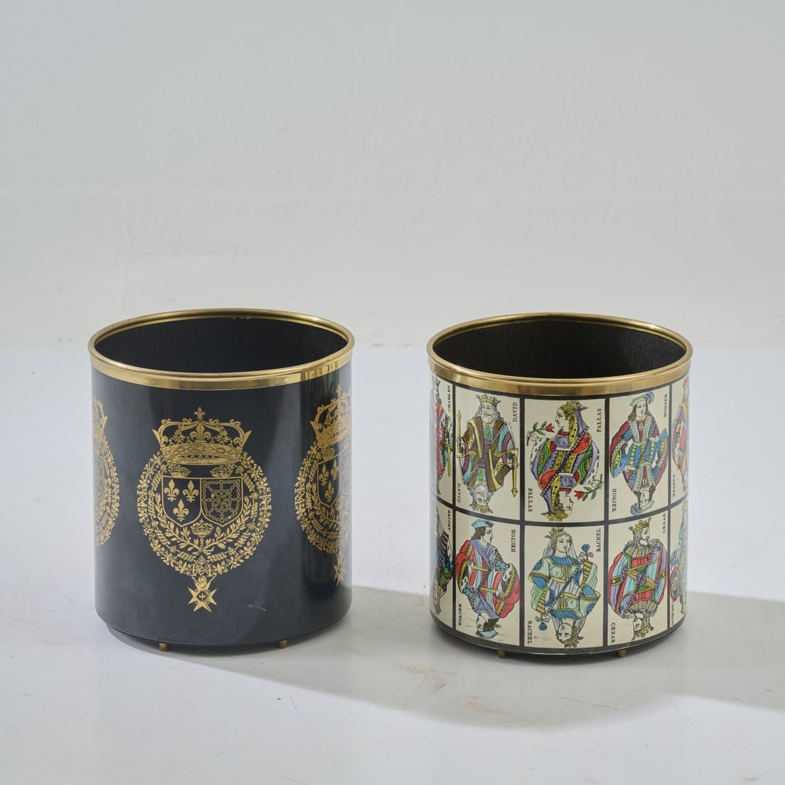 Piero Fornasetti, Wastepaper basket 'Carte da gioco' and another model, 1950s (design): <p>H. 28.5 cm, &Oslash; 26.5 cm. <br />Fornasetti, Milan. <br />Black lacquered sheet metal with gold lithographic decoration on brass sheet. <br />Marked: Each bears the