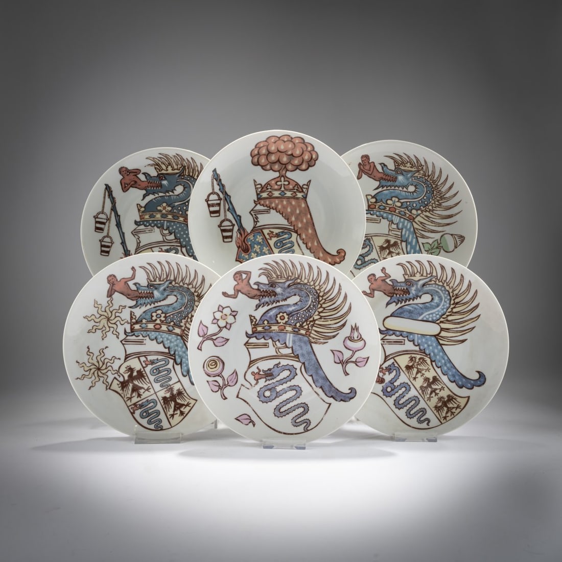 Piero Fornasetti, Six plates from the series 'Iconografia degli stemmi Viscontei', 1970s: <p>&Oslash; 24 cm. <br />Fornasetti, Milan, for Alfa Romeo, Milan. <br />Porcelain, white, glazed, polychrome overglaze. <br />Marked: Manufacturer and designer's informati