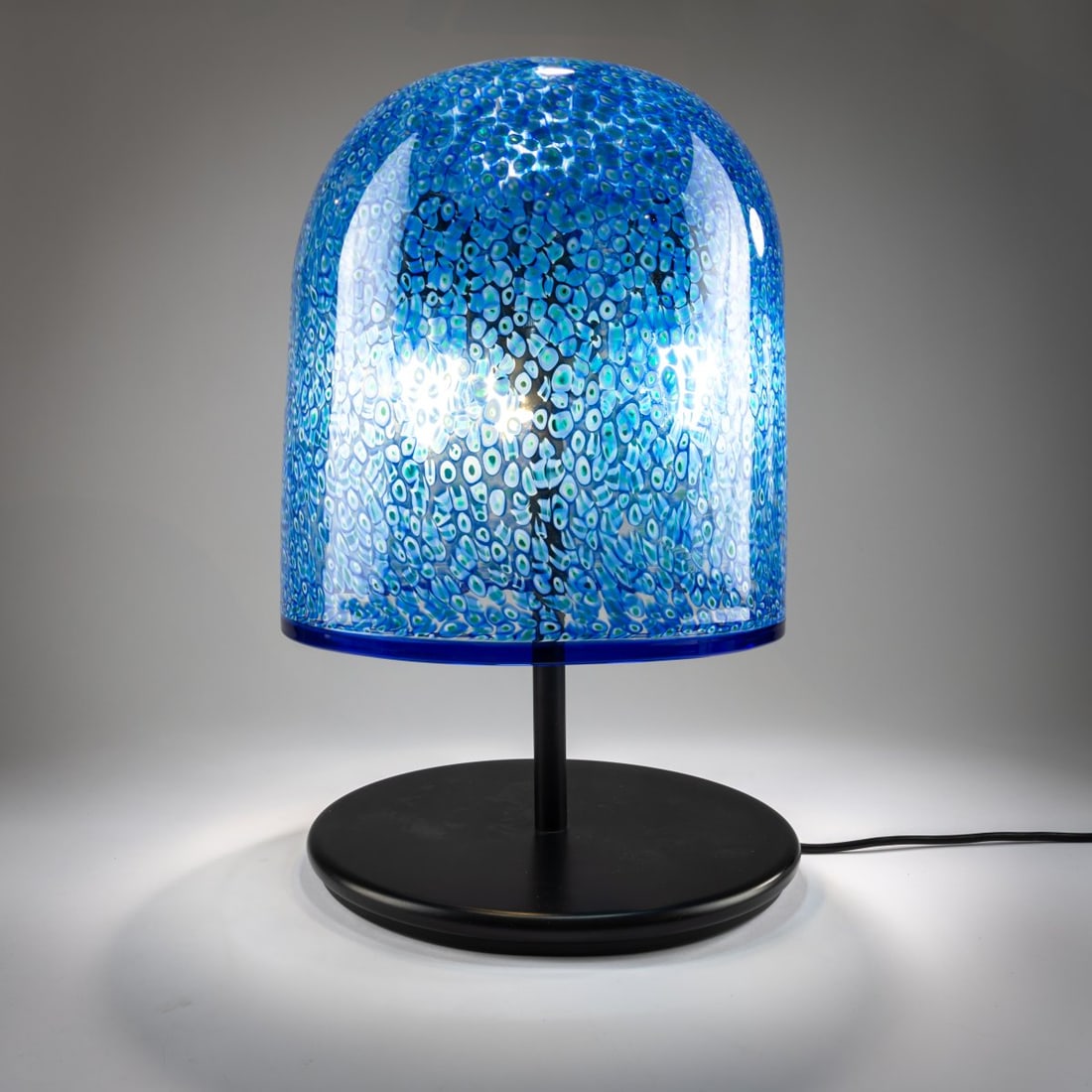 Gae Aulenti, 'Neverrino' table light, 1970 (design): <p>H. 47 cm, &Oslash; 30,5 cm. <br />Vetreria Vistosi, Murano. <br />Metal tube, sheet metal, lacquered black, colorless glass with fused murrine in blue, white, and green, rim b