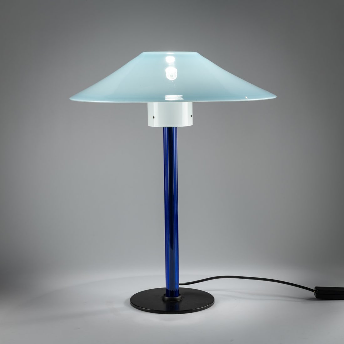 Cini Boeri, Table light 'Chiara', 1984: <p>H. 57 cm, &Oslash; 45 cm. <br />Venini, Murano, 1986. <br />Cast metal, black, colorless glass with fused dark blue rods, opal white and light blue. Marked: Venini 86 (engrave
