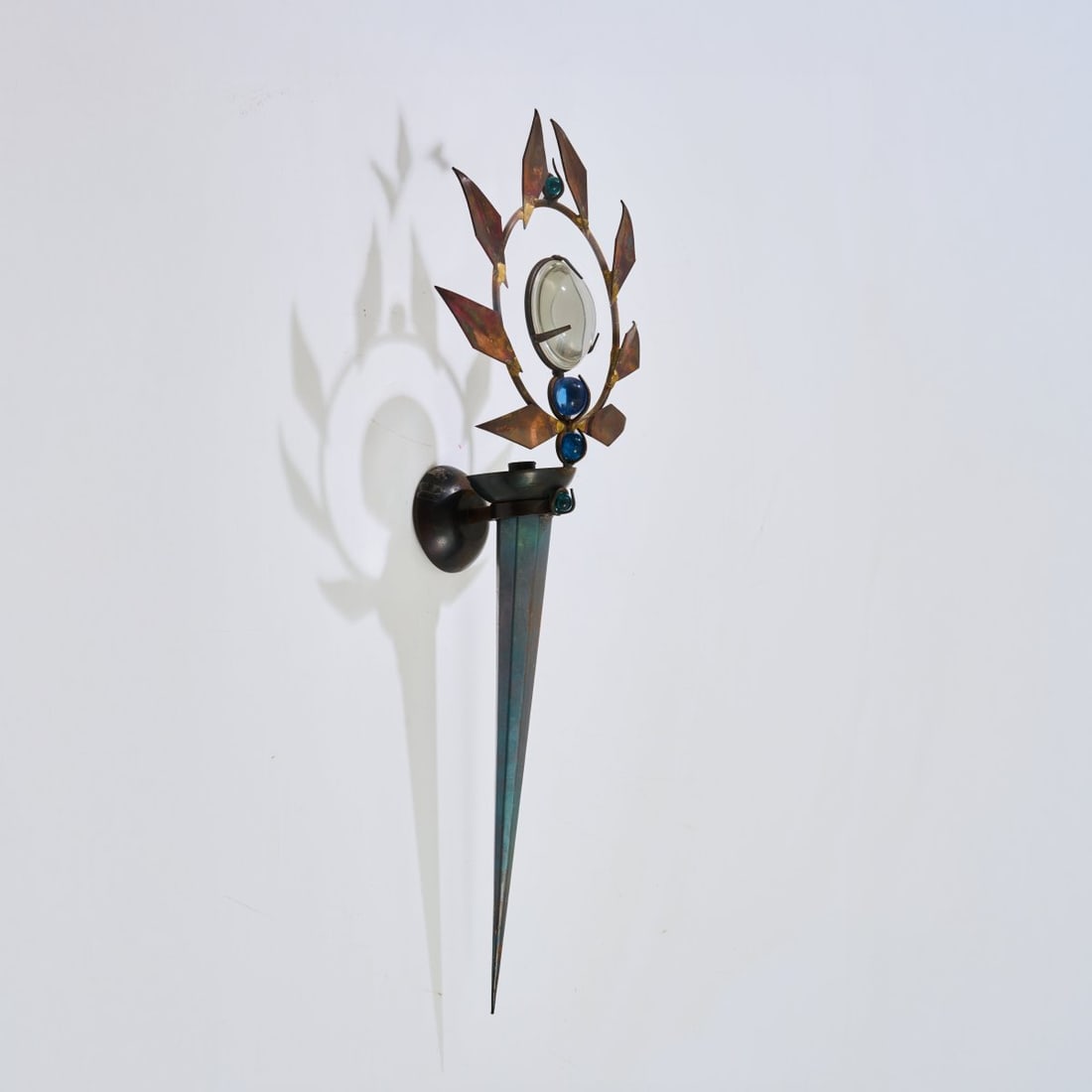 Mark Brazier-Jones, Wall sconce 'Olympia', 1986 (design): <p>H. 75 cm. <br />Mark Brazier-Jones, Buckland, Buntingford. <br />Copper sheet, blackened metal, optical glass, four blue glass spheres. </p>