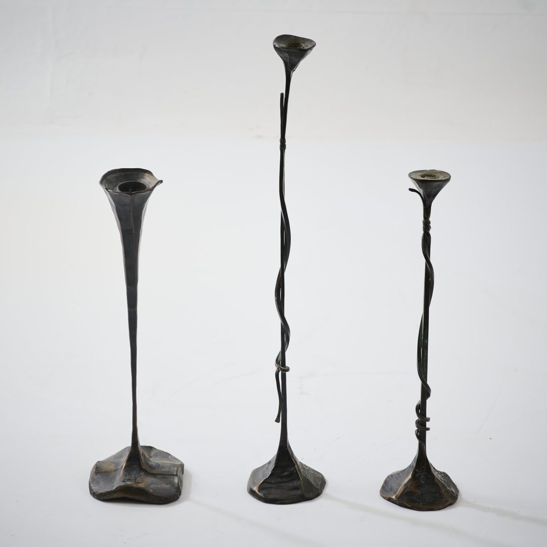 Lothar Klute, Three candle holders, 1989-1992: <p>H. 38.5&ndash;53.5 cm. <br />Klute, in der Waldemai, Schmallenberg, 1989&ndash;1992. <br />Bronze, forged, dark patina. <br />Marked: Artist's signature LK 89 (2x),