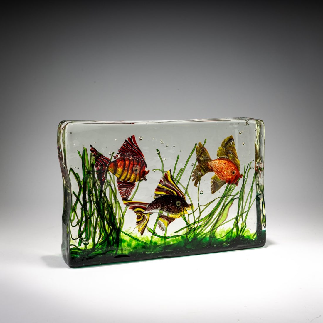Gino Cenedese, Aquarium, c. 1955: <p>H. 20 cm, 31 x 6.5 cm. Colorless glass block with underwater landscape fused in multicolored glass masses.</p>
