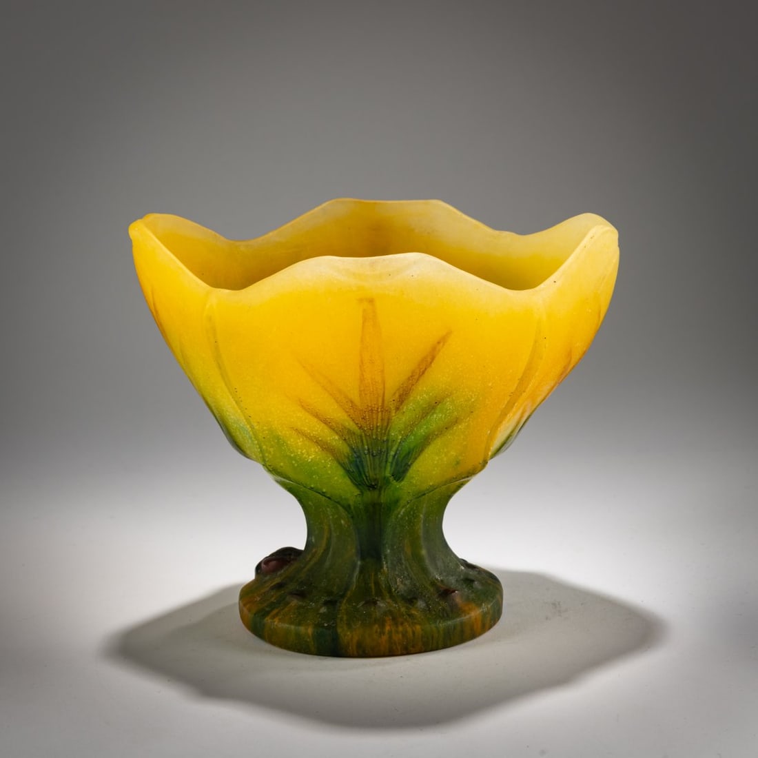 Amalric Walter, Nancy, Footed vase, c. 1925: <p>H. 15.2 cm, &Oslash; 18 cm. P&acirc;te de verre, translucent glass, molded, predominantly yellow, with green and brownish powder inclusions, stylized leaf decoration. Foot signed: AWa