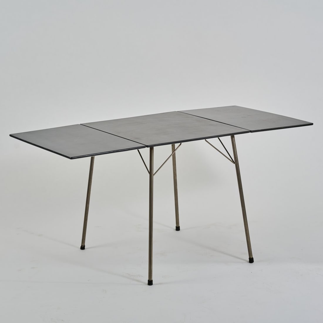 Arne Jacobsen , Folding table '3601', 1952 (design): <p>H. 68.5 x 62 - 140 x 70 cm. <br />Fritz Hansen, Aller&oslash;d. <br />Nickel-plated metal tube, black lacquered wood. </p>