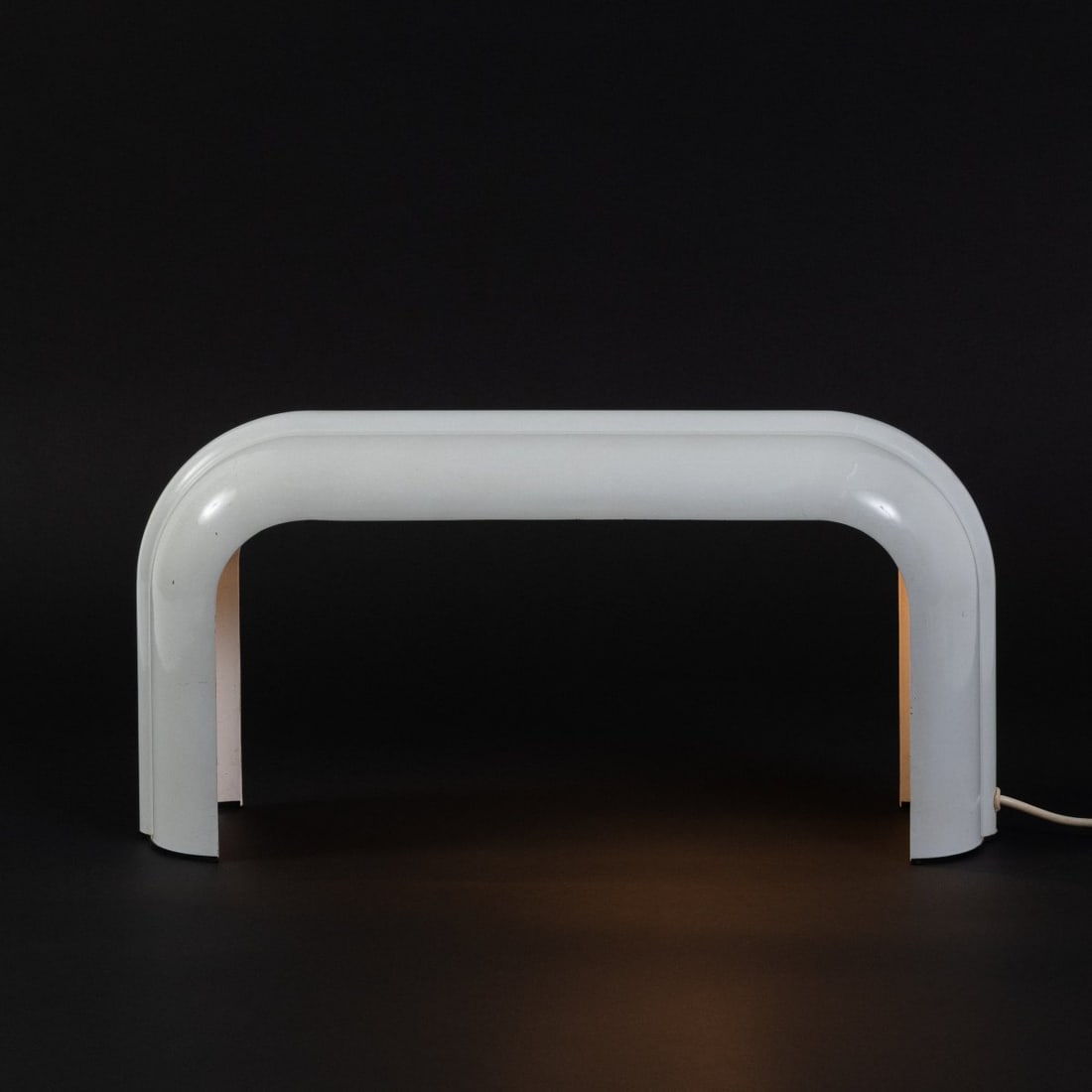 Luciano Annichini, Table light 'Eco', c.1972 (design): <p>H. 26 x 52,5 x 13,5 cm.<br />Artemide, Milan. ?Cast metal, enameled white, black plastic.?Marked: Manufacturer's mark with all details.</p>