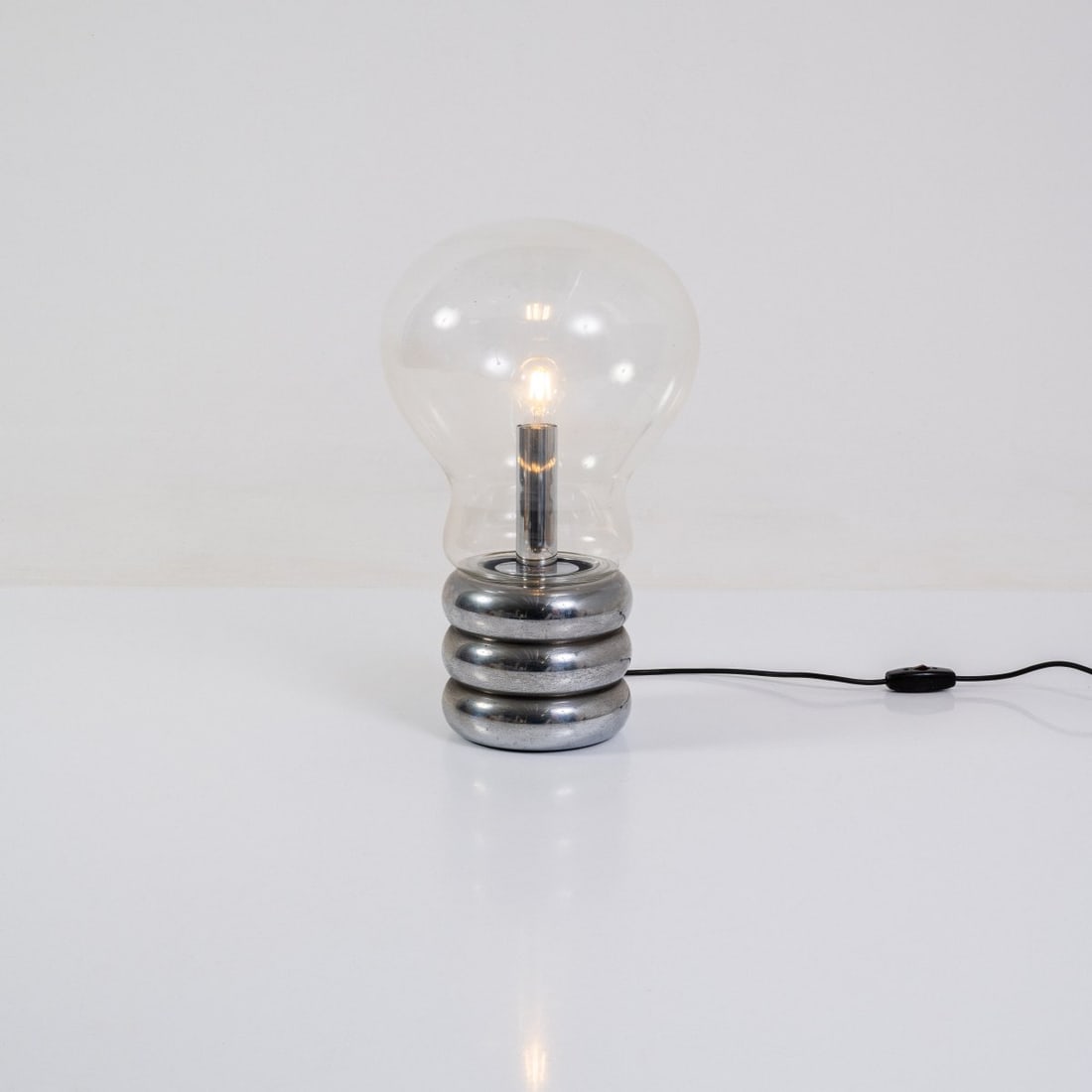 Ingo Maurer, Table light 'Giant Bulb Clear', 1966 (design): <p>H. 55 cm.<br />Desin M, Ingo Maurer, Munich. <br />Chrome-plated sheet metal, colorless glass.</p><hr><p>Literature:</p><p>Bauer (ed.), Ingo Maurer M