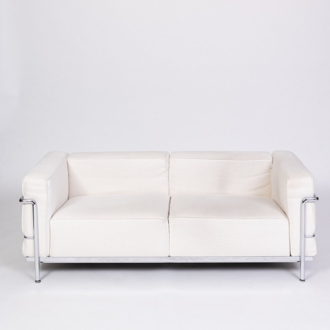 Le Corbusier Charles-Édouard Jeanneret-Gris; Pierre Jeanneret; Charlotte Perriand, Two-seater: <p>H. 60 x 70 x 167 cm. <br />Cassina, Milan, 1990s. <br />Chrome-plated tubular steel, white textile upholstery. <br />Marked: Cassina, manufacturer's mark, LC3, No. 19382,
