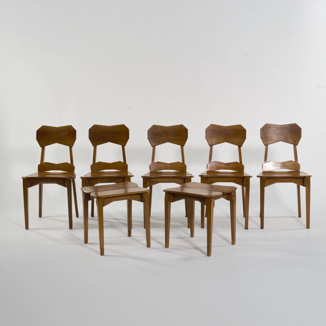 Paul Bay, Five anthroposophical chairs and two stools, 1940s (design): <p>Chairs: H. 86 x 45 x 50 cm; stools: H. 45.5 x 46 x 41 cm.<br />Kunstschnitzwerkstatt Dornach (attributed). <br />Beechwood, elm, dark glaze. <br />Marked: Address stamp of