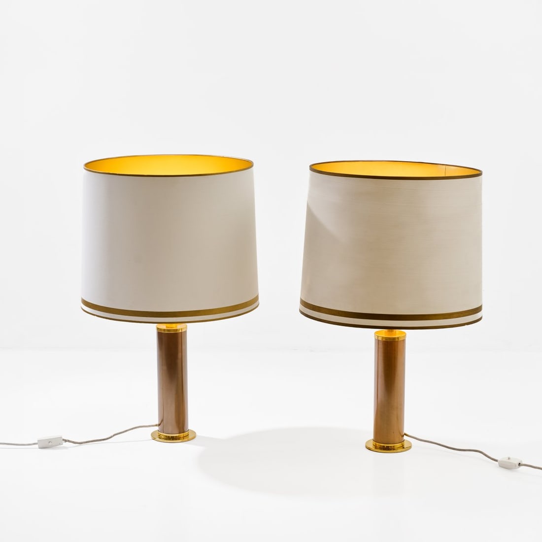 Vereinigte Werkstätten, Munich, Two table lights, 1980s (design): <p>H. 74 cm, &Oslash; 46.5 cm. <br />Brass sheet, metal tube, brown lacquer, cr&egrave;me-white fabric shade, gold-colored foil lining. <br />Marked: Manufacturer's sticker