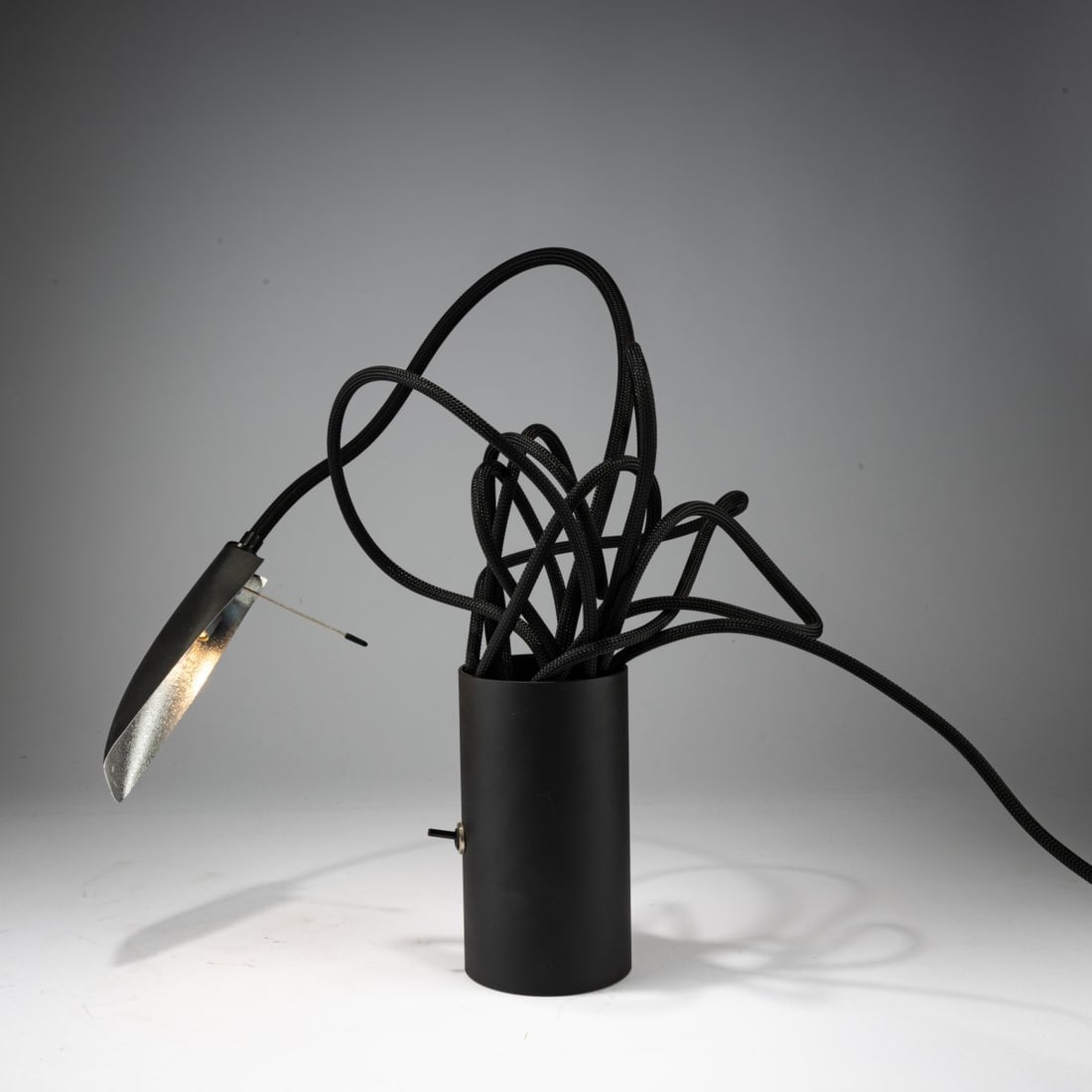 Tobias Reischle, Table light 'Kuddelmuddel', 2008 (design): <p>H. 86 cm (max). <br />Ingo Maurer, Munich. <br />Sheet metal, black lacquer, rubber cable, aluminum sheet, black lacquer. <br />Marked: Manufacturer's label.</p>