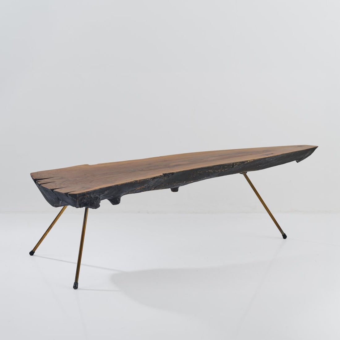 Carl Auböck, Tree trunk table, c. 1955 (design): <p>H. 48 x 156 x 55 cm. <br />Workshop of Carl Aub&ouml;ck, Vienna. <br />Tree trunk section, walnut, brass tube. <br />Marked: Manufacturer's stamp 17, MADE IN