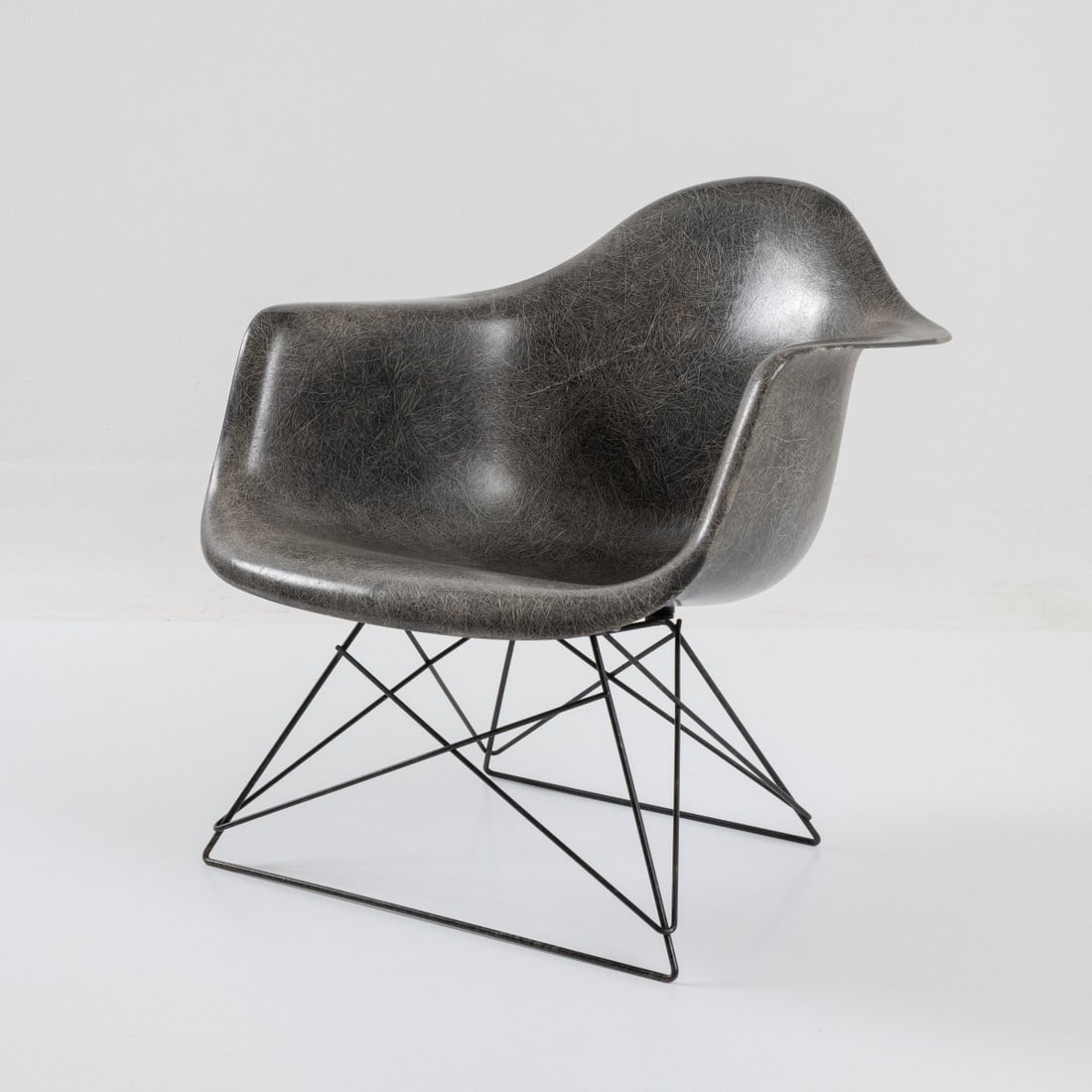 Charles Eames; Ray Eames, Armchair 'LAR' - 'Cats Cradle', 1950 (design): <p>H. 62 x 63 x 62 cm. <br />Herman Miller, Zeeland. <br />Plastic, reinforced with fiberglas, dark gray, chrome-plated metal rods, rubber buffers.<br />Marked: Remnants of a