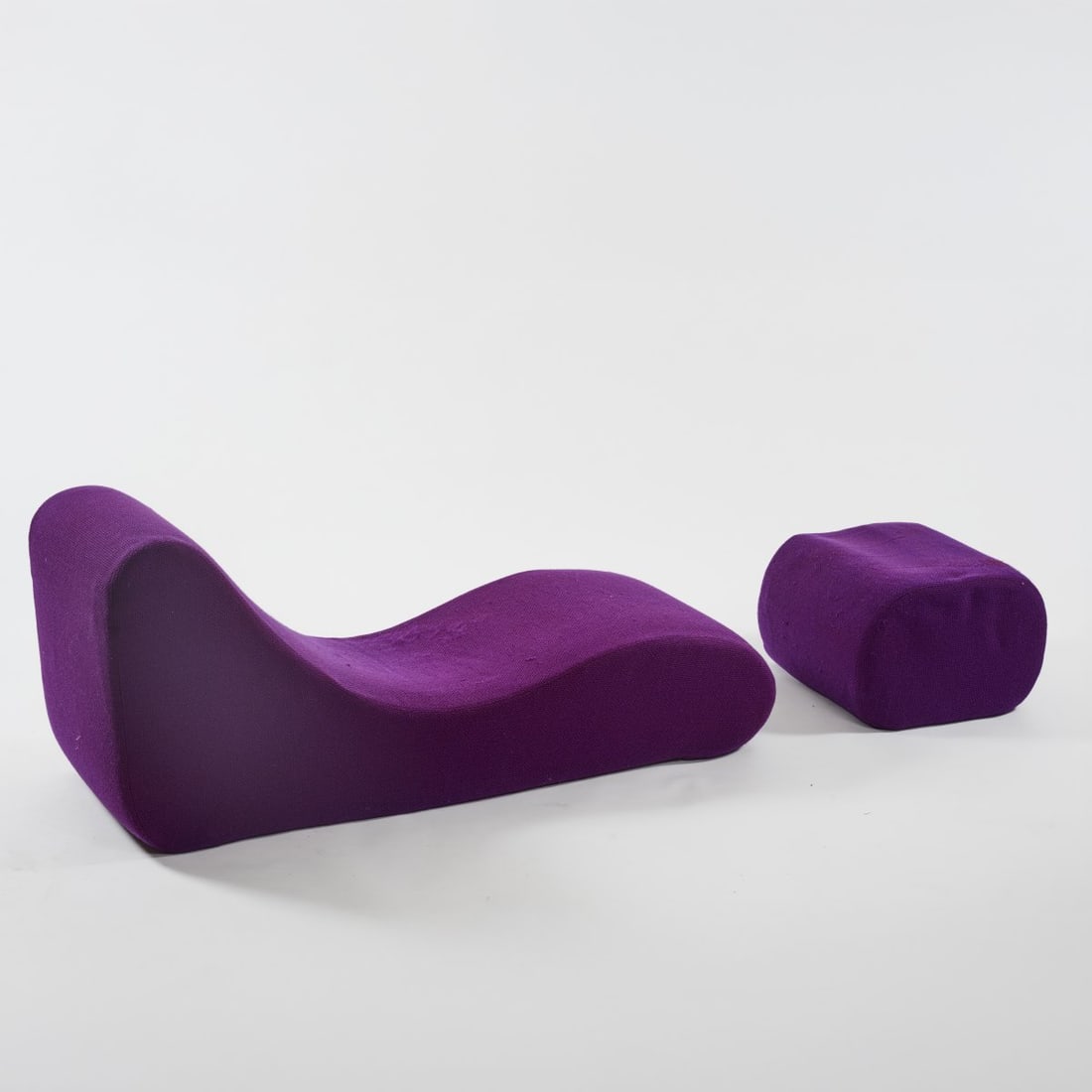 Verner Panton, Chaise longue and ottoman from the 'Wave' series, 1969/70 (design): <p>Lounger: H. 61 x 150 x 52 cm, Stool: H. 35 x 50 cm. <br />Metzeler Foam, Munich. <br />Cold foam molded parts, fabric cover, violet.</p><hr><p>Literature:</p&