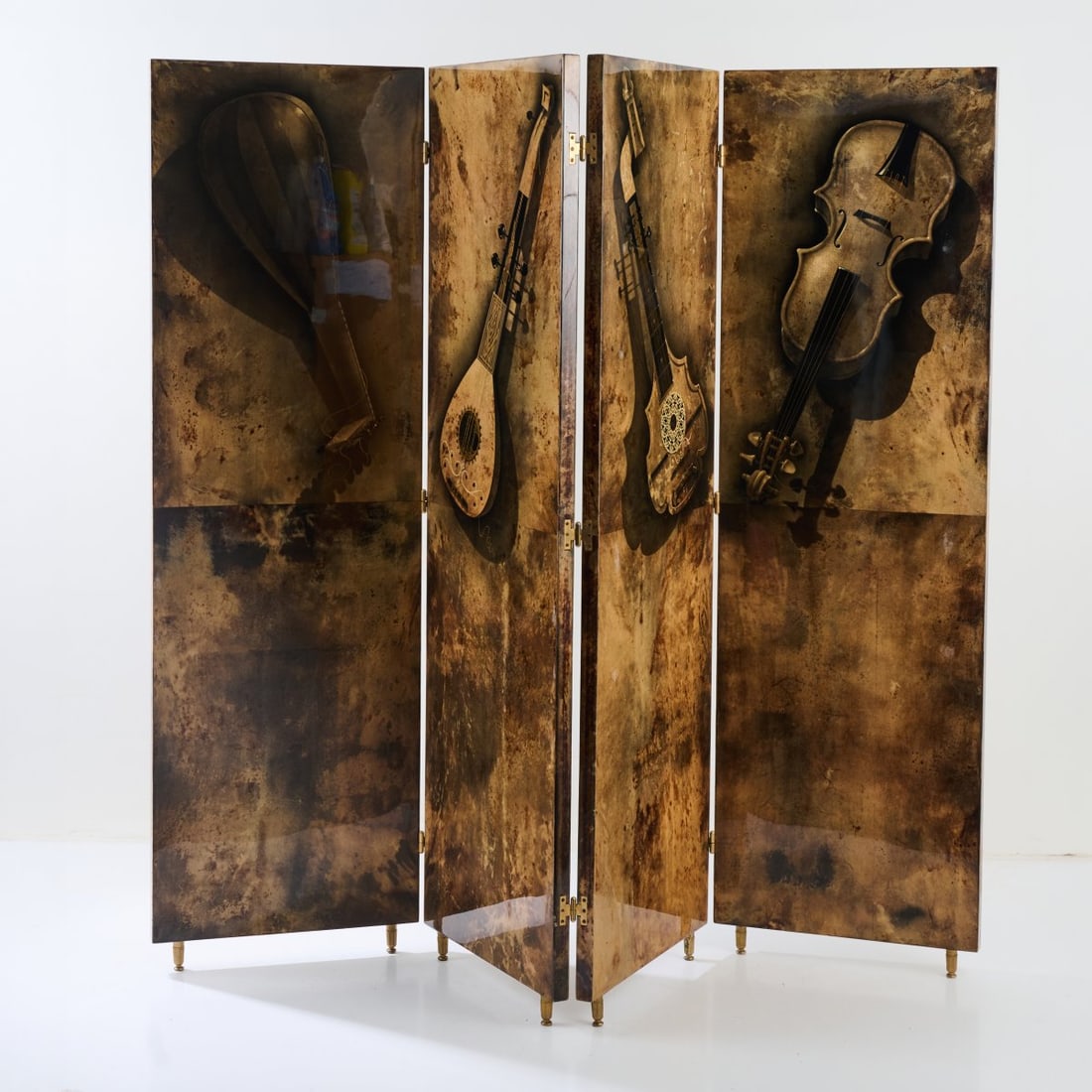 Aldo Tura, Folding screen 'Strumenti Musicali', 1960s/70s (design): <p>H. 165.5 x 200 x 3 cm. <br />Tura, Milan. <br />Wood covered with brown goatskin and printed with a motif of musical instruments, black ink, brown and gold drawing. <br />Ma