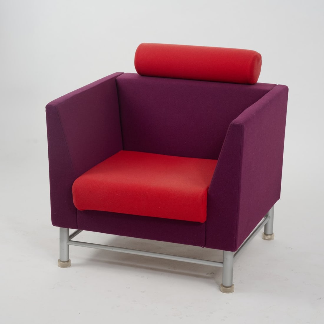 Ettore Sottsass, Armchair from the 'Eastside Collection', 1982 (design): <p>H. 86 x 83 x 79 cm. <br />Knoll International, New York. <br />Satin-finished steel with transparent plastic feet, wooden frame, foam padding, wool upholstery, purple and red. <