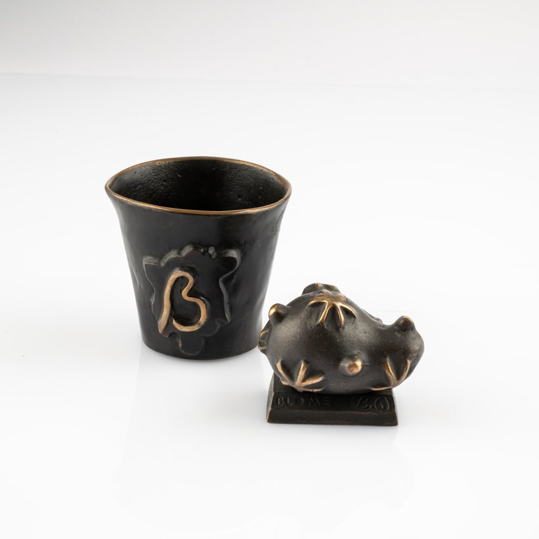 Garouste & Bonetti, Four-piece placemat set from the 'Edition Blome' series, 1994-2001 (design): <p>H. 5-6.5 x 4.5 x 6 cm, &Oslash; 7.5 cm; bowls: h. 2-2.5 cm, &Oslash; 9 cm. Hubert Blome GmbH, Sundern-Stockum. <br />Bronze, black patinated, partially polished. <br />Mar