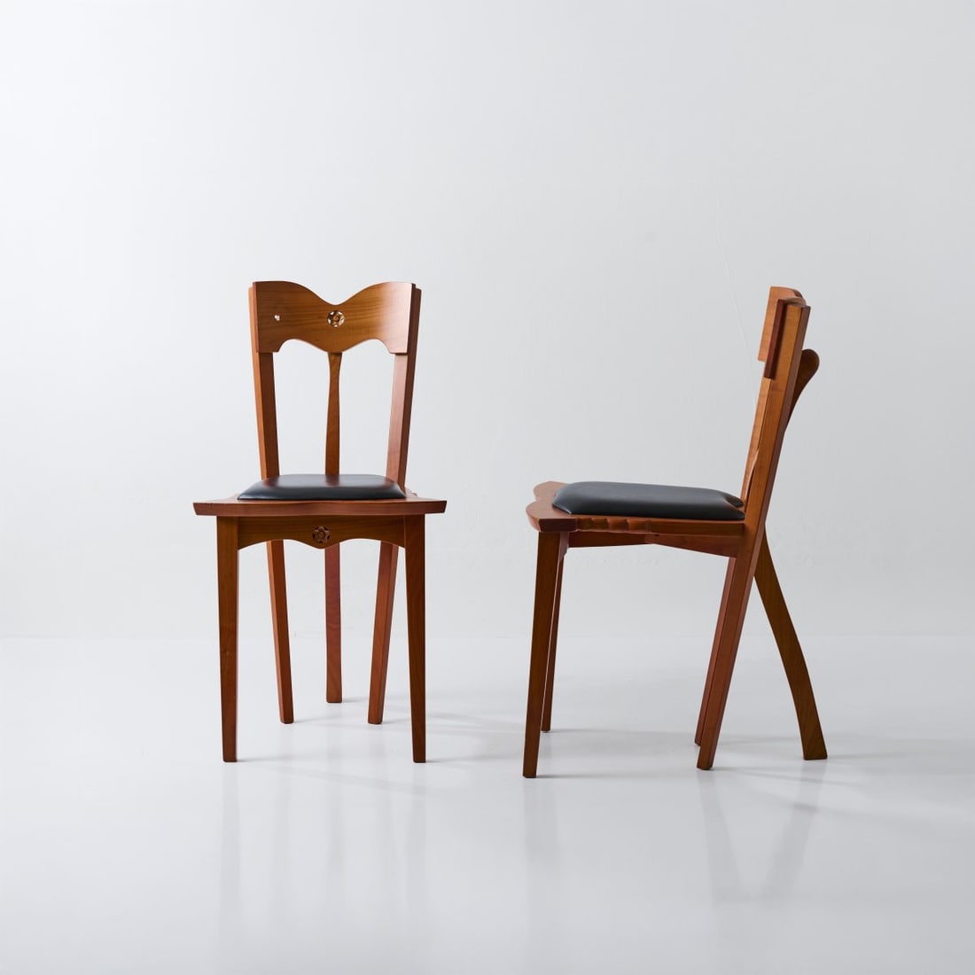 Bo?ek Šípek, Two chairs 'Dora', 1991 (design): <p>H. 81 x 44 x 49 cm. <br />Driade Aleph, Corsico. <br />Cherry wood, black leather cover. <br />Marked: Manufacturer's sticker.</p>