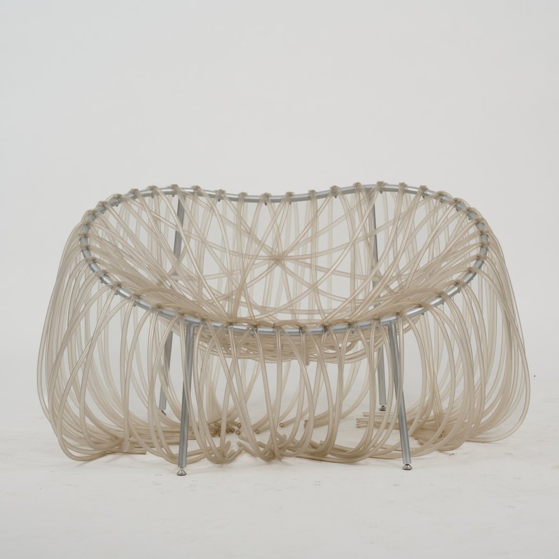 Fernando Campana; Humberto Campana , Armchair 'Anemone', 2000 (design): <p>H. 63 x 110 x 76 cm. <br />Edra, Milan, 2000s. <br />Metal tube, anodised silver-gray, colorless PVC tubing.</p><hr><p>Literature:</p><p>Hudson,