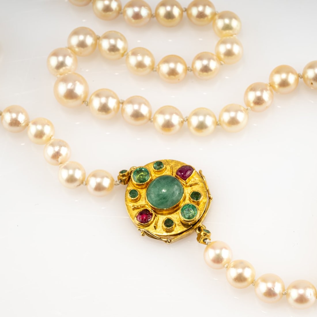 Hermann Jünger (1928 Hanau - 2005 Pöring n. Munich), Clasp with pearl necklace, 1968: <p>Yellow gold, rubies, emeralds, pearls. <br />66.51 grams. L. (opened) 940 mm. <br />Stamped: artist's mark.</p>