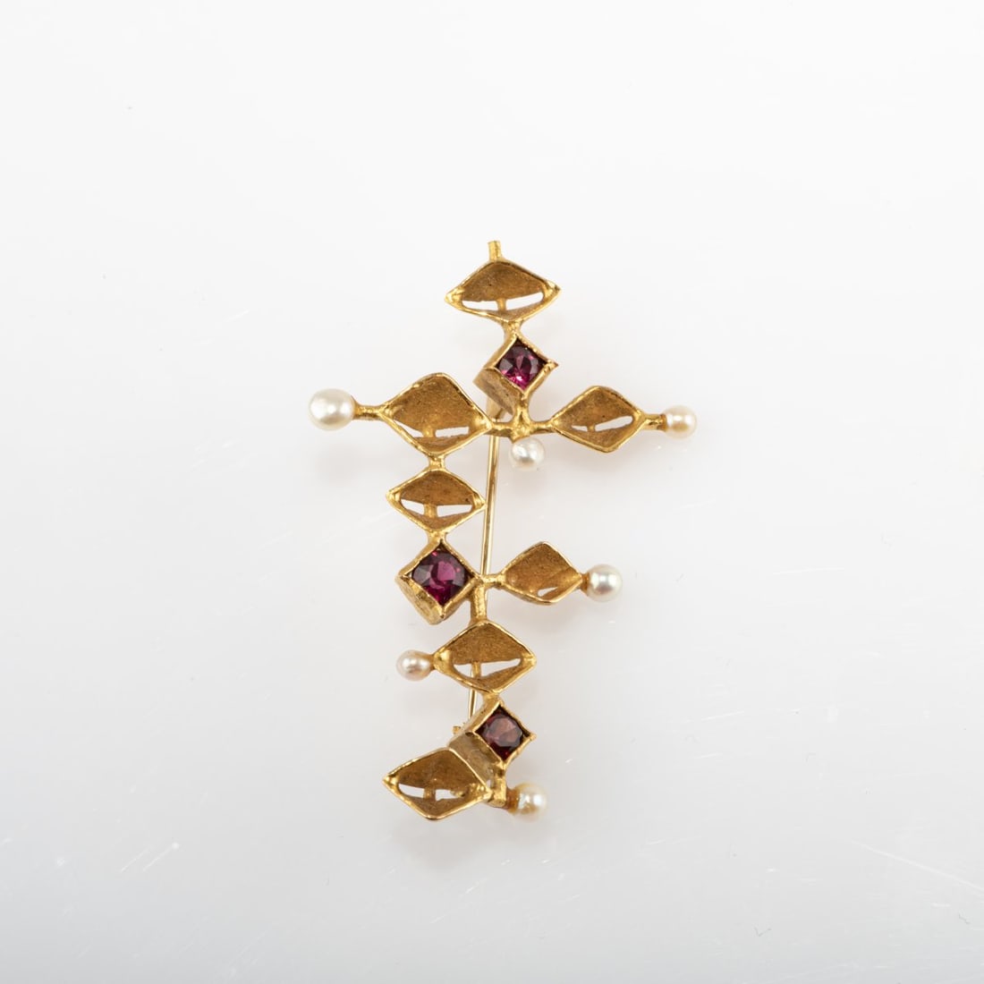 Klaus Ullrich (1927 Sensburg - 1998 Pforzheim), Brooch, around 1965: <p>18k yellow gold (750), 3 rubies, 6 pearls. <br />6.41 grams. 34 x 54 mm. <br />Stamped: 750, artist's signet. </p>