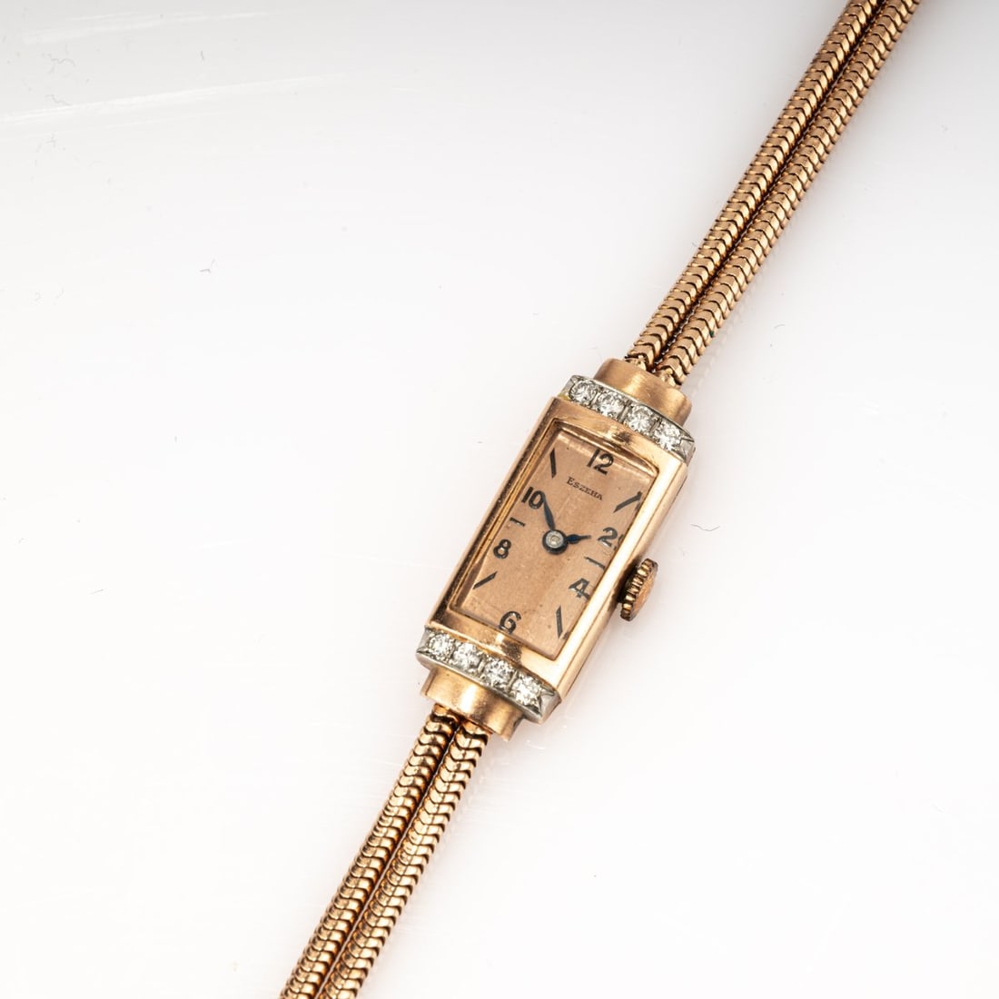Eszeha, Pforzheim, Art Deco Eszeha women's watch, 1930s: <p>14k rose gold (585), diamond setting, rose-colored dial. <br />18.80 grams. Case 28 x 13 mm, L. 130 mm. <br />Stamped: Eszeha, 0.585.