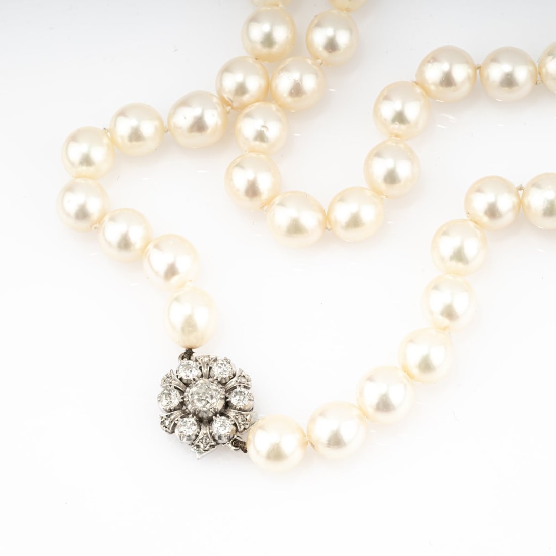 , Pearl necklace with diamond clasp: <p>18k white gold (750), 7 old-cut diamonds and 6 diamond chips (total approx. 1.85 ct., calculated weight), 43 cultured pearls. <br />55.71 grams. L. 460 mm. <br />Stamped: 750. <