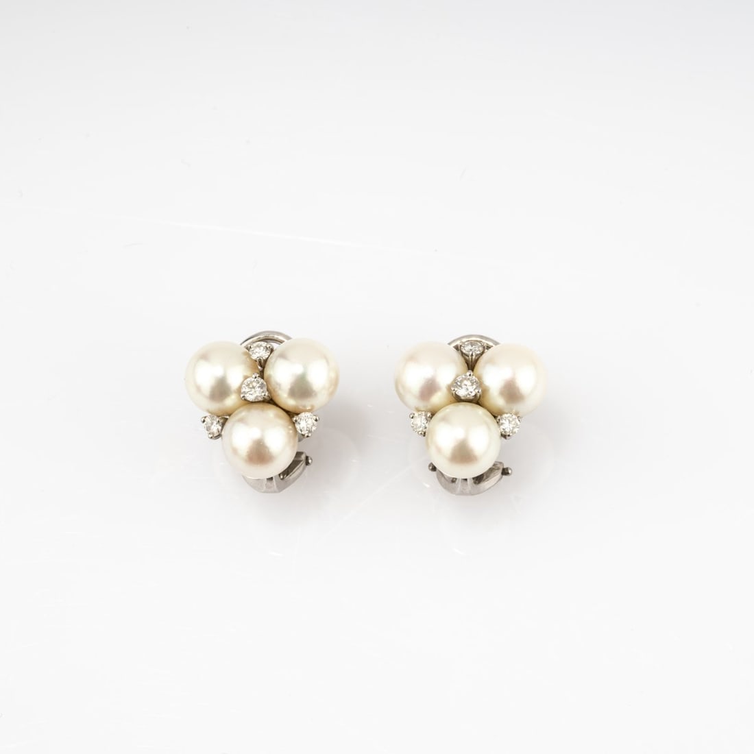 Gübelin, Swiss, Pair of stud earrings with pearls and diamonds: <p>18k white gold (750), three pearls and four small brilliant-cut diamonds. <br />Total weight 7.28 grams. 14 x 14 mm. <br />Stamped: 750, workshop mark.</p>