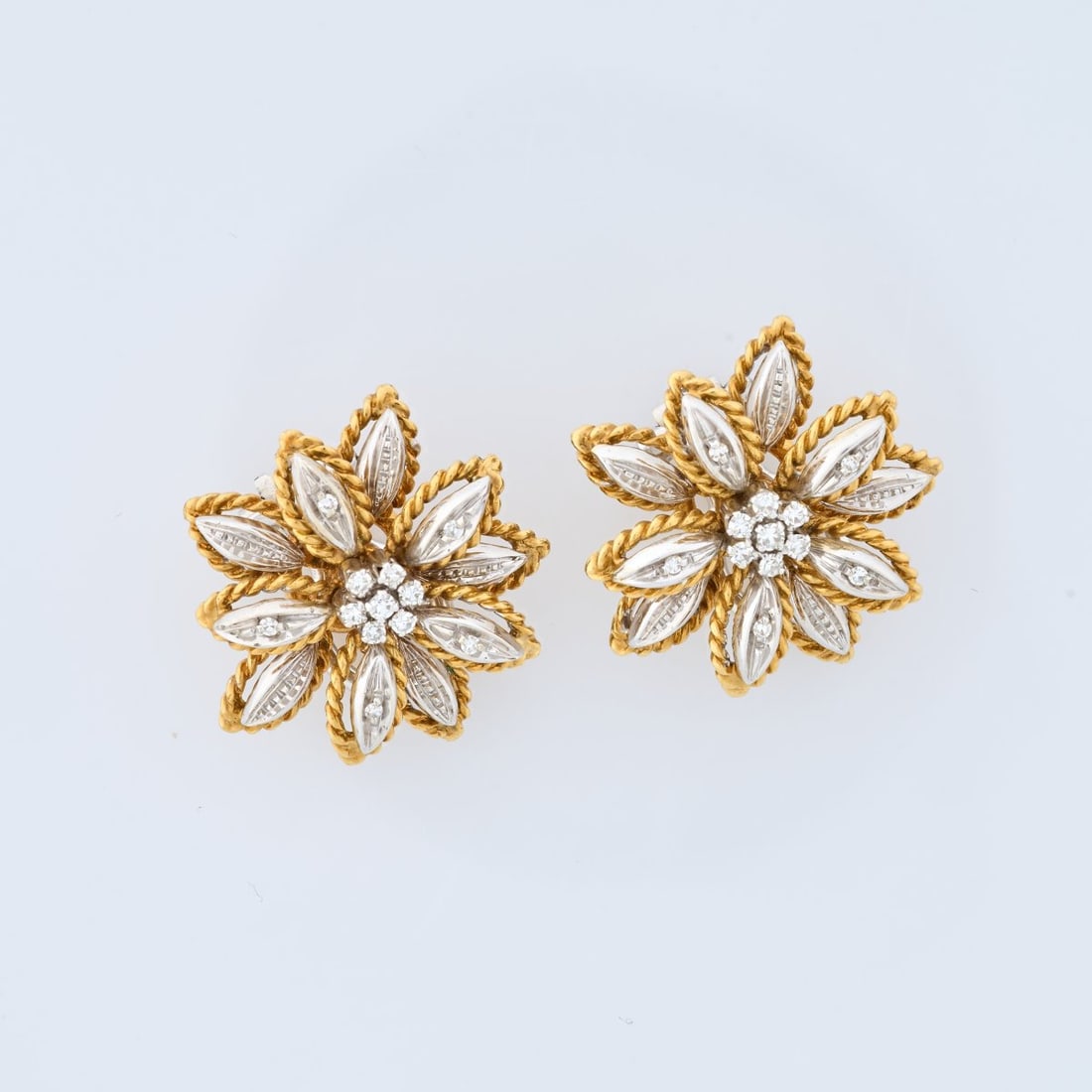 Italy, Pair of flower-shaped clip-on earrings: <p>18k yellow and white gold (750), each set with 12 small brilliant-cut diamonds. <br />14.71 grams. &Oslash; 22 mm. <br />Stamped: 18K, Italy.</p>