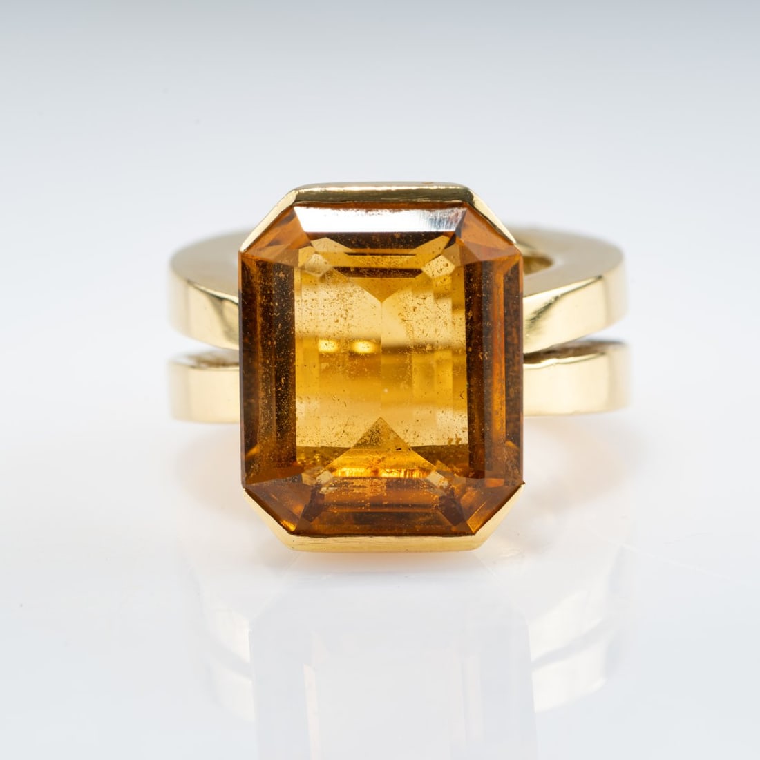 , Cocktail ring with gold-colored citrine: <p>18k yellow gold (750), gold-colored citrine in an emerald cut (approx. 11.6 ct., calculated weight). <br />28.59 grams. Ring size 51. <br />Stamped: 750.</p>