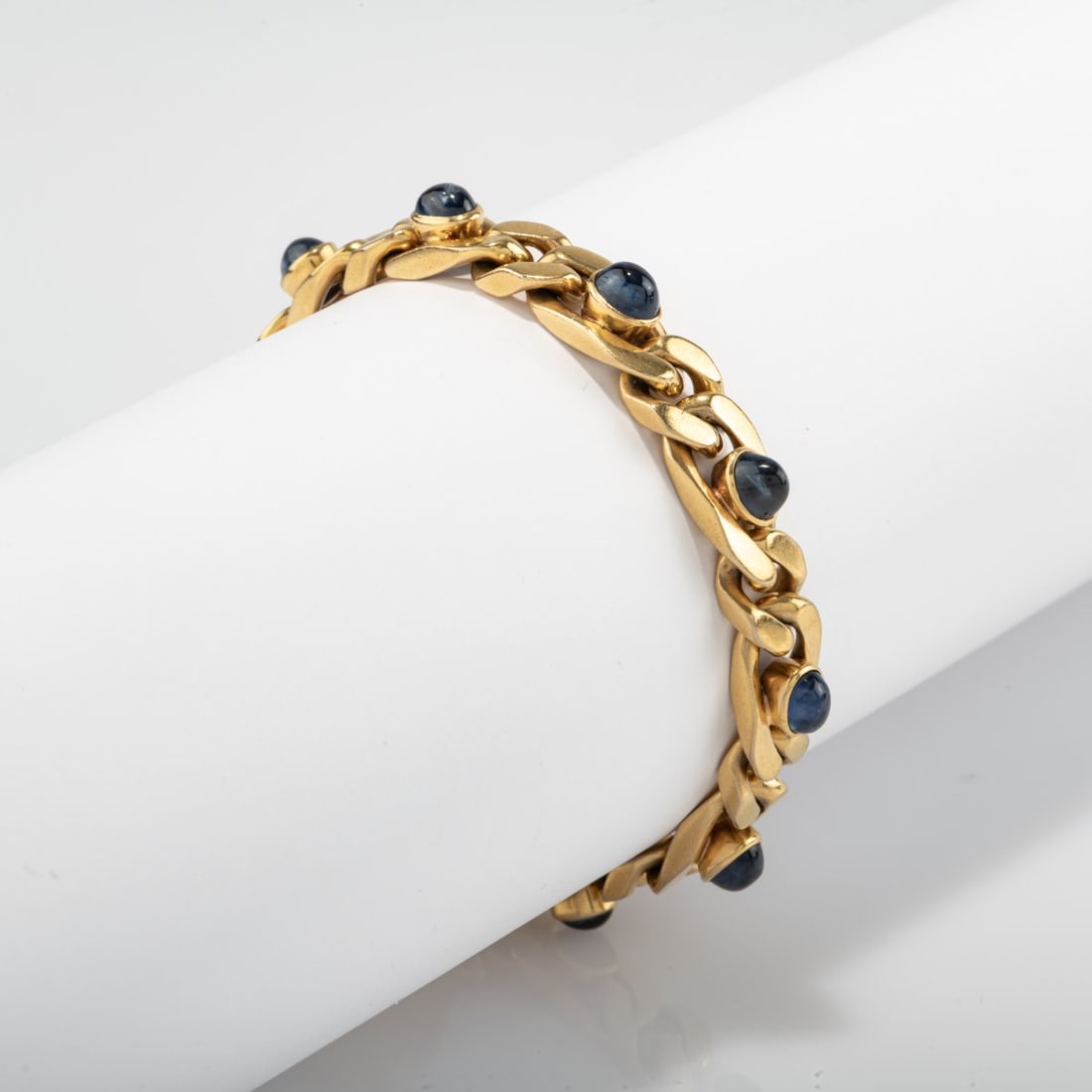 , Curb bracelet with sapphire cabochons: <p>18k yellow gold (750), 10 sapphire cabochons. <br />44.39 grams. L. 180 mm. <br />Stamped: maker's mark SK, 750. </p>